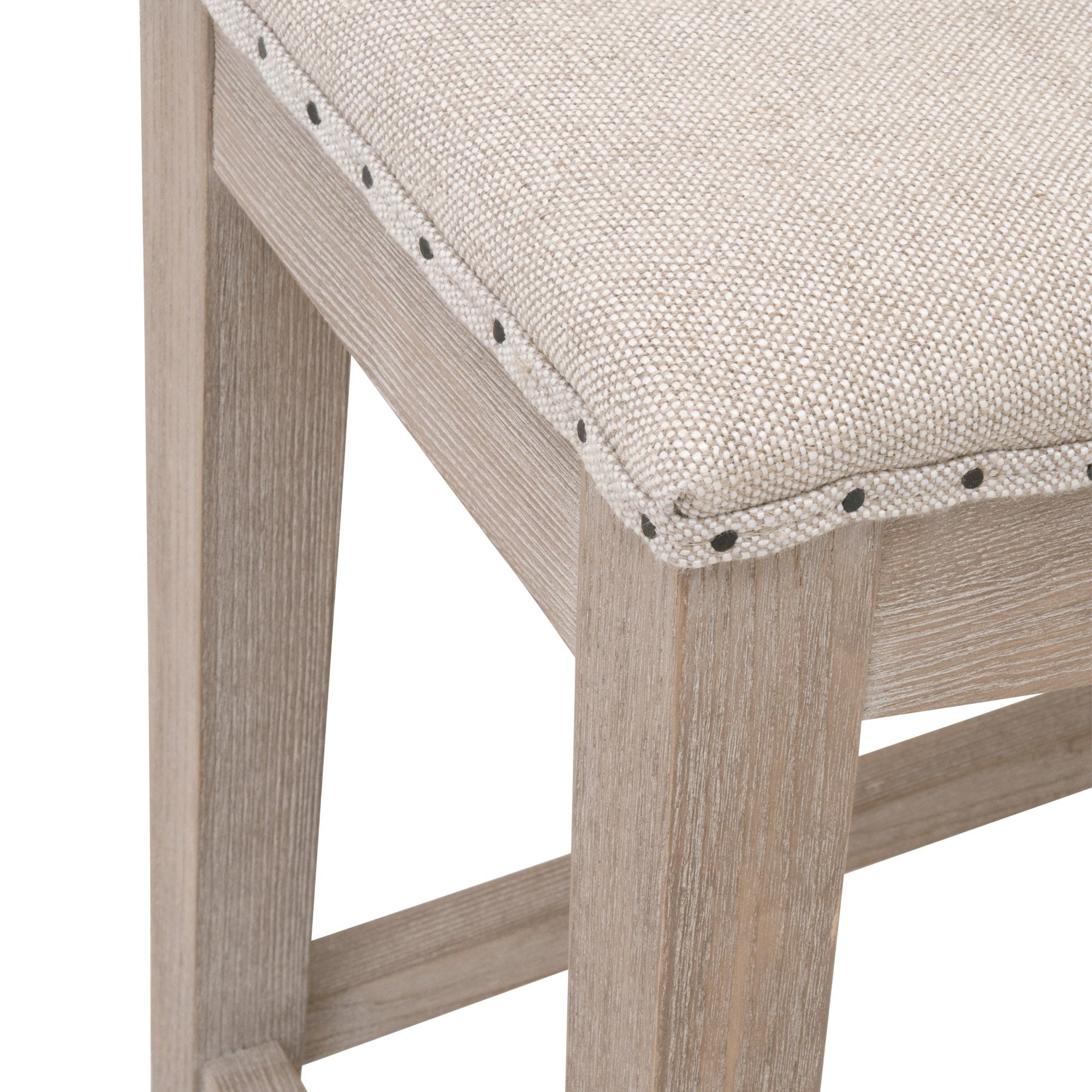 Close-up of Harper Counter Stool seat with bisque French linen upholstery and natural gray ash wood frame by Essentials for Living.