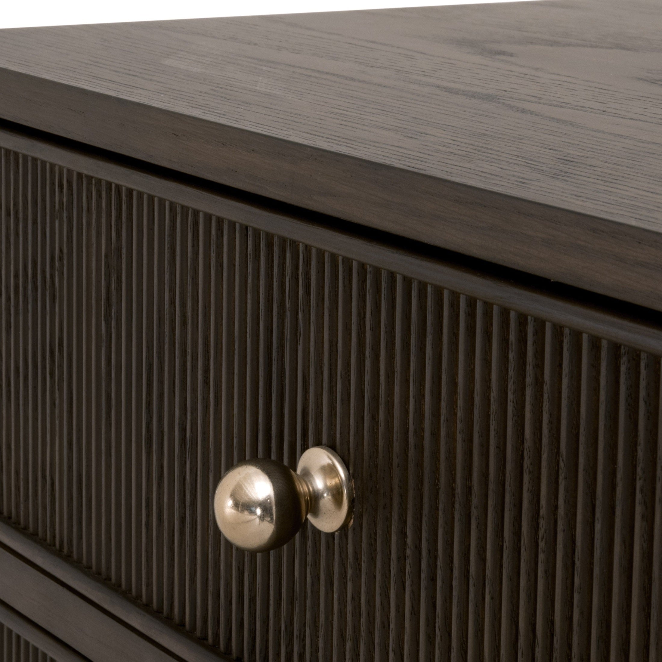 Close-up of dark oak nightstand drawer with fluted detailing and polished brass knob by Essentials For Living