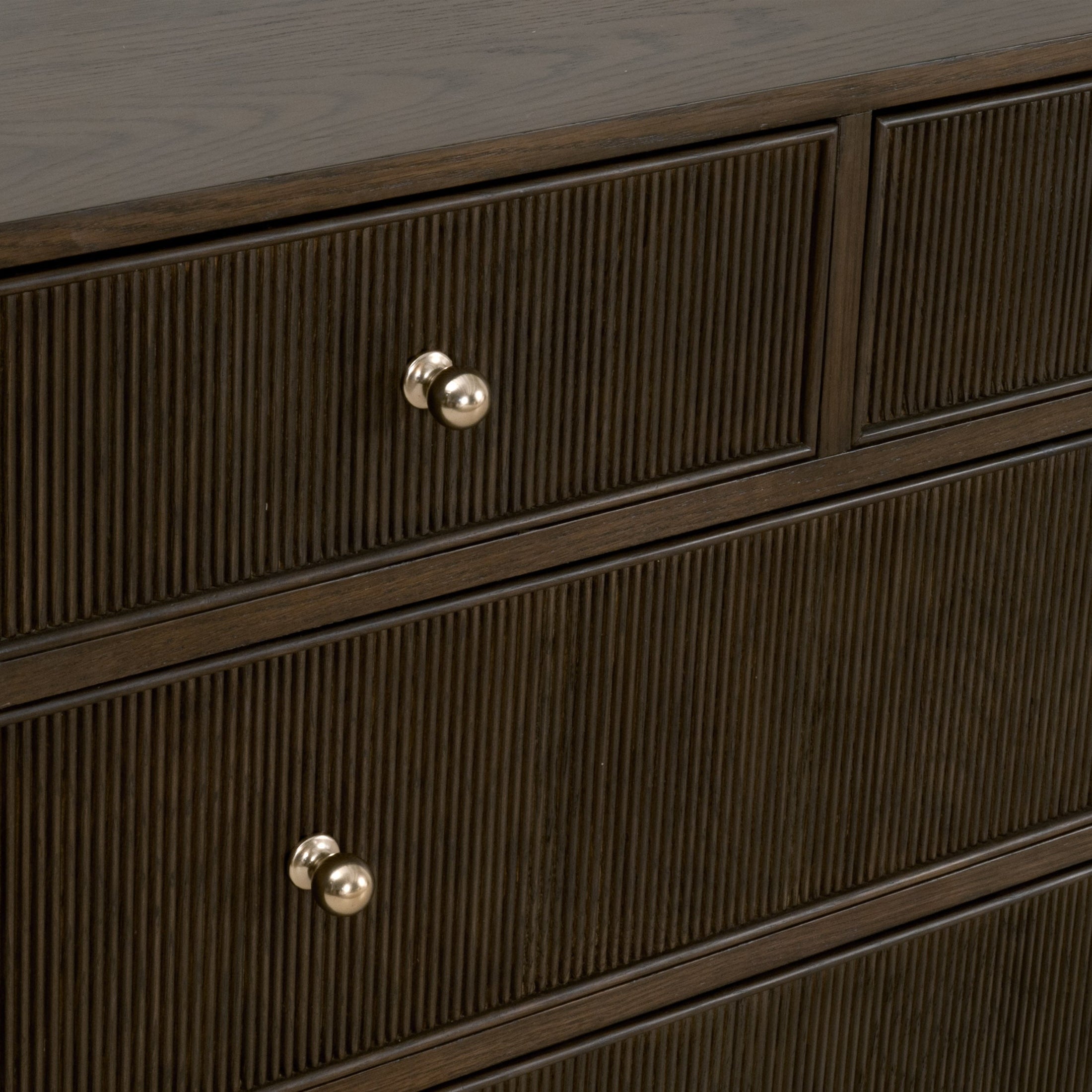 Close-up of fluted wood drawer fronts with polished brass finish iron knobs on Highland double dresser