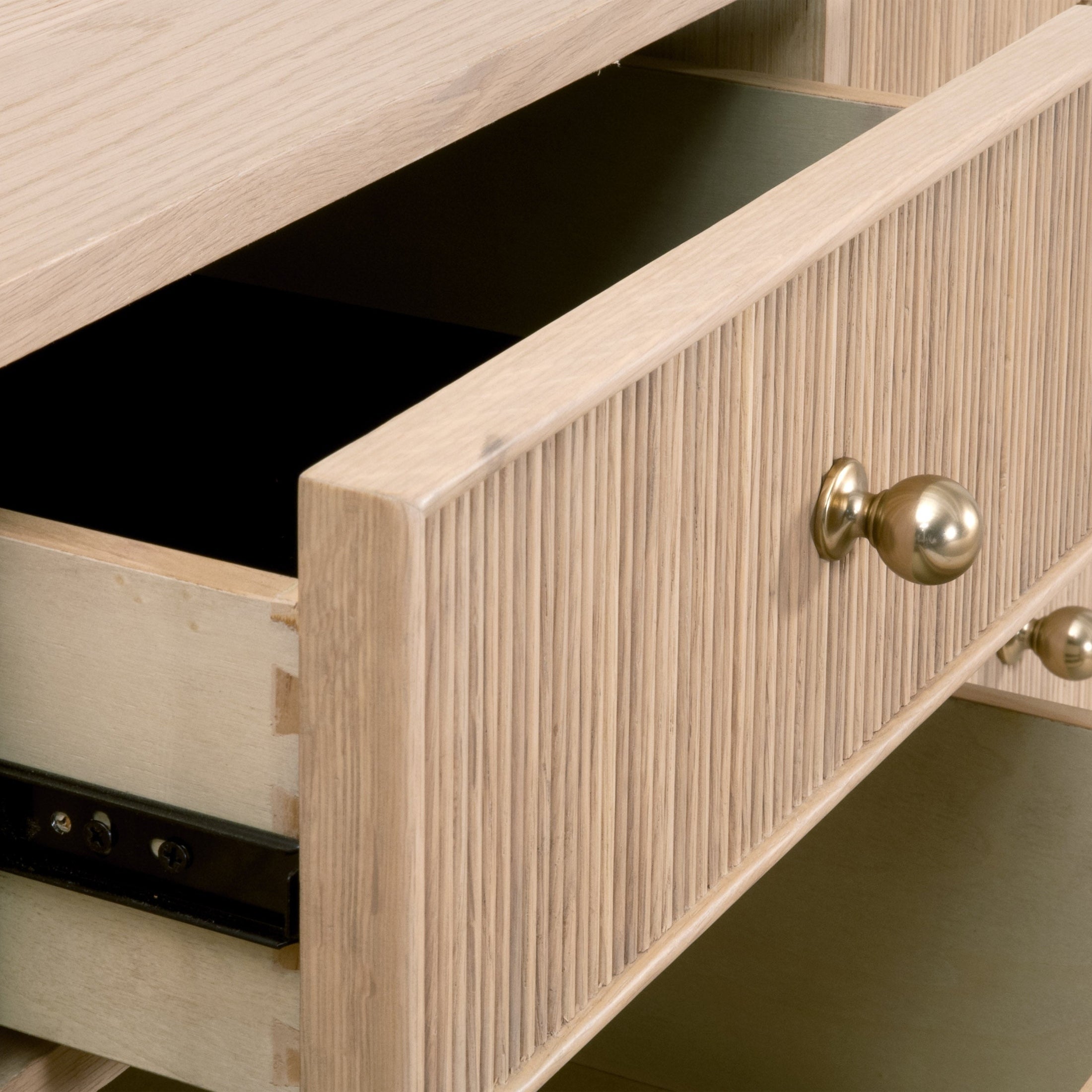 Close-up of an open drawer on the Highland 8-Drawer Double Dresser showing fluted wood and brass knob details