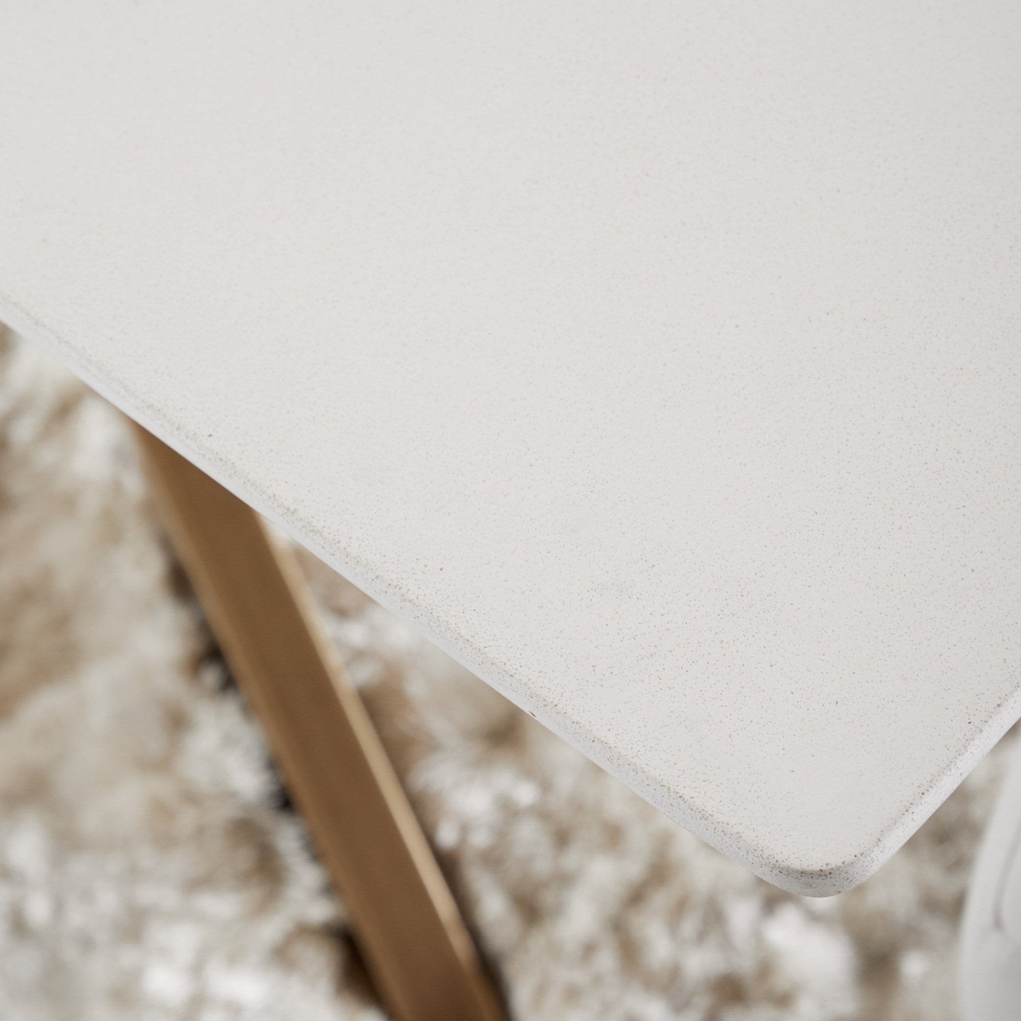 Close-up of the ash gray nano-sealed concrete tabletop with angled edge and whiskey oak wood and iron base accents.