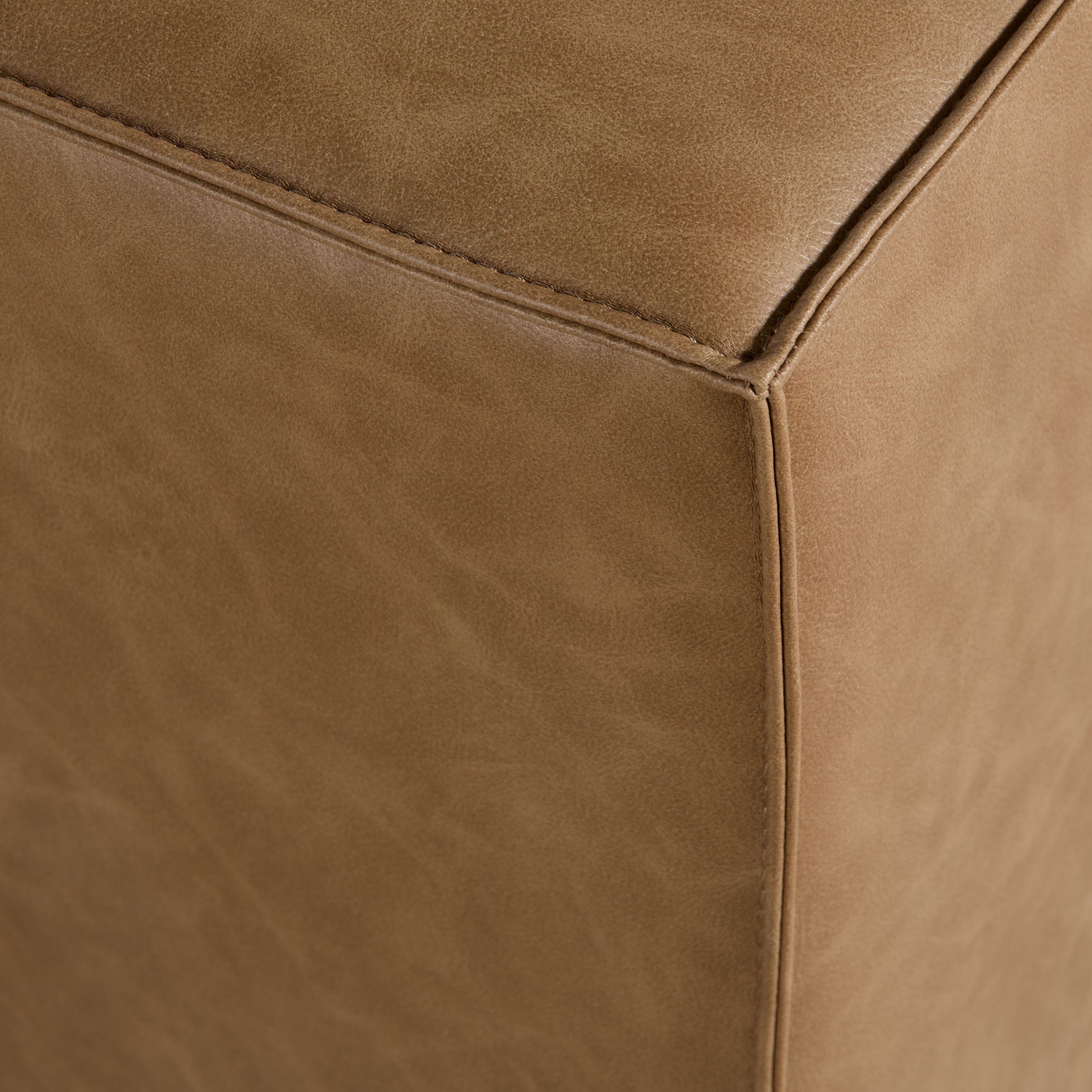 Close-up of brown upholstered corner detail on Knox Accent Cube by Essentials for Living showing smooth fabric and stitching.