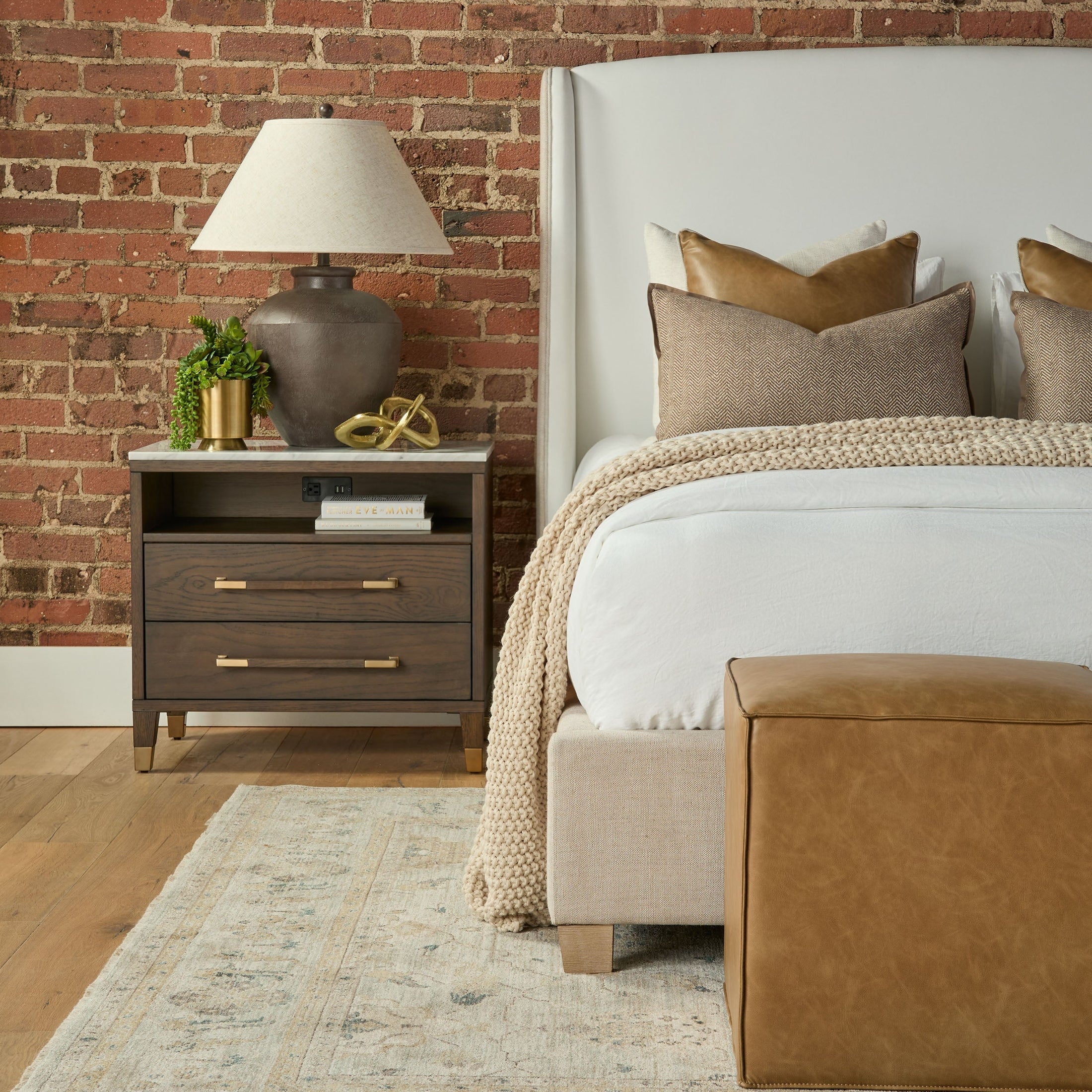 Knox Accent Cube upholstered in LiveSmart fabric beside bed with neutral bedding and wooden nightstand in cozy room