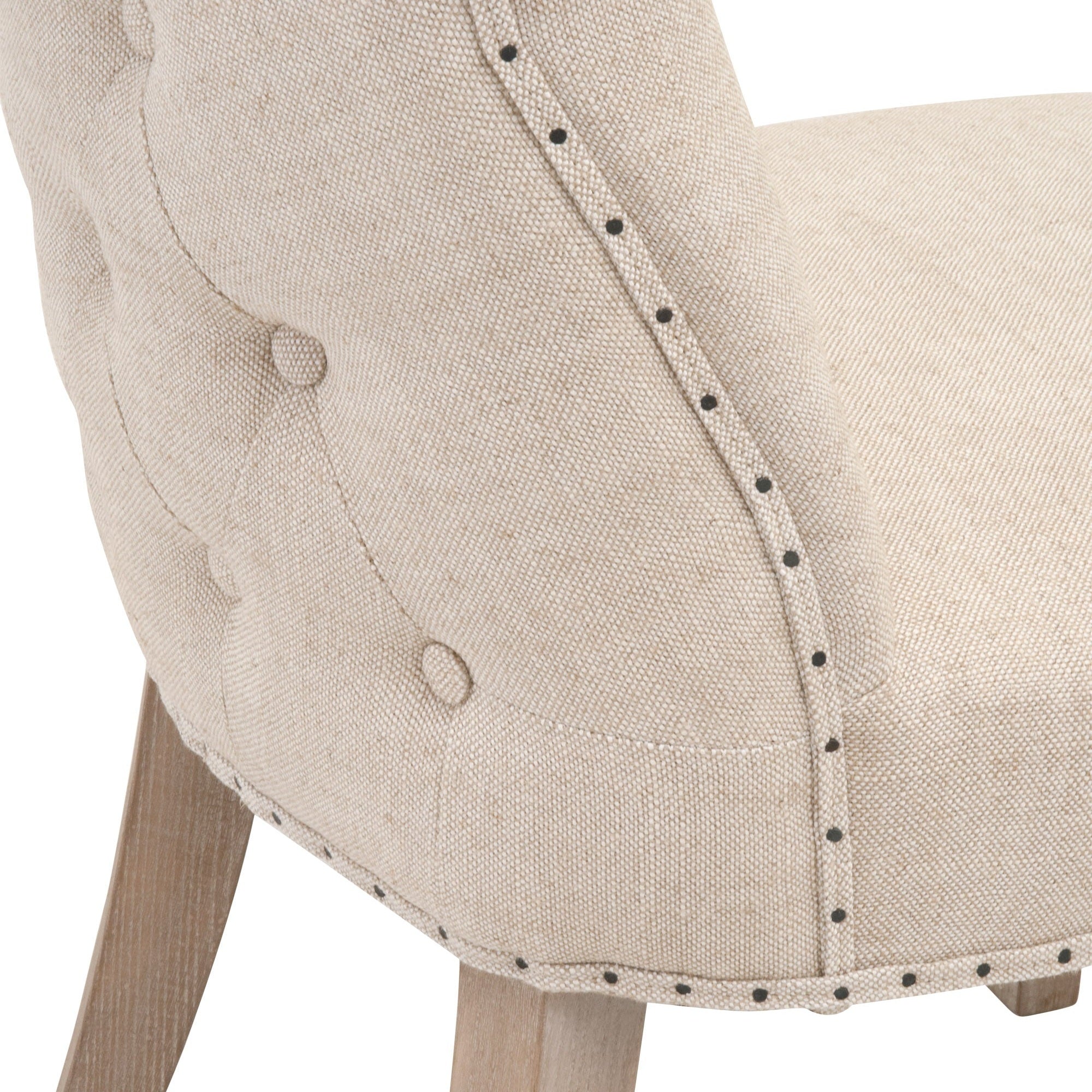 Close-up of Lourdes Dining Chair with button-tufted bisque linen upholstery and nailhead trim by Essentials for Living