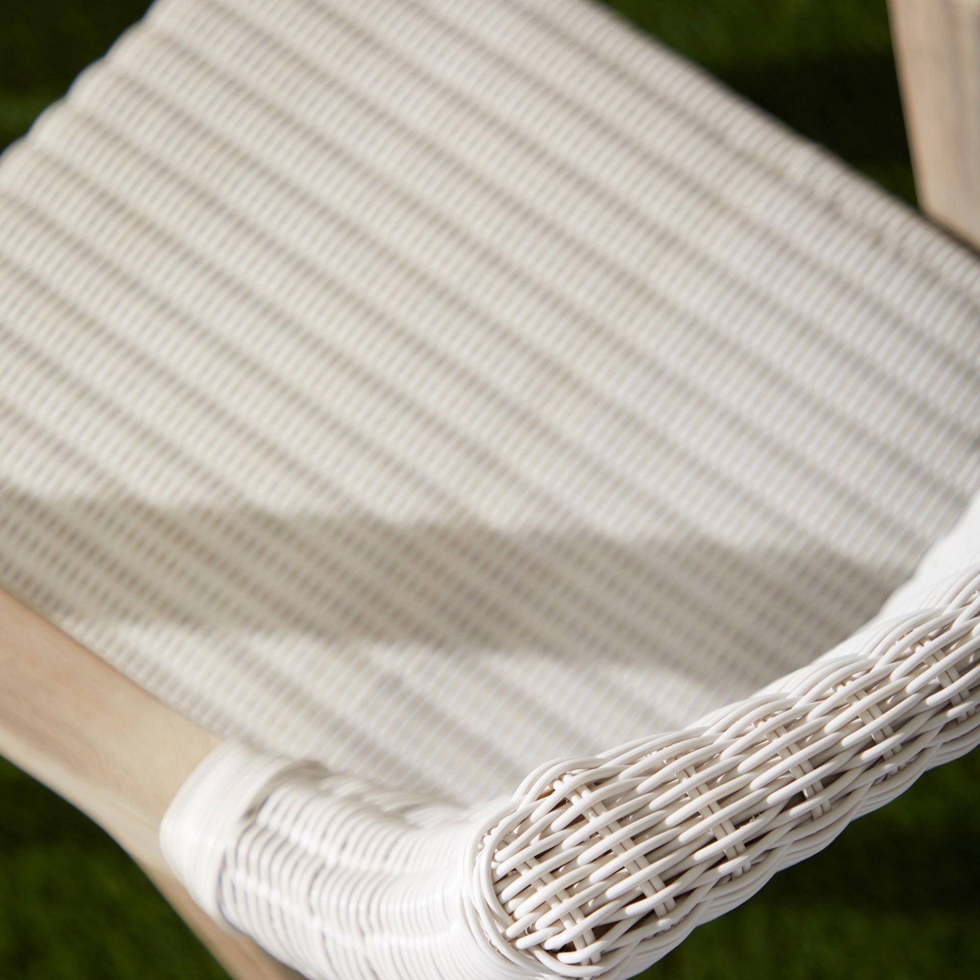 Close-up of Essentials for Living Lucia Outdoor Arm Chair showing white synthetic wicker and gray teak wood frame detail