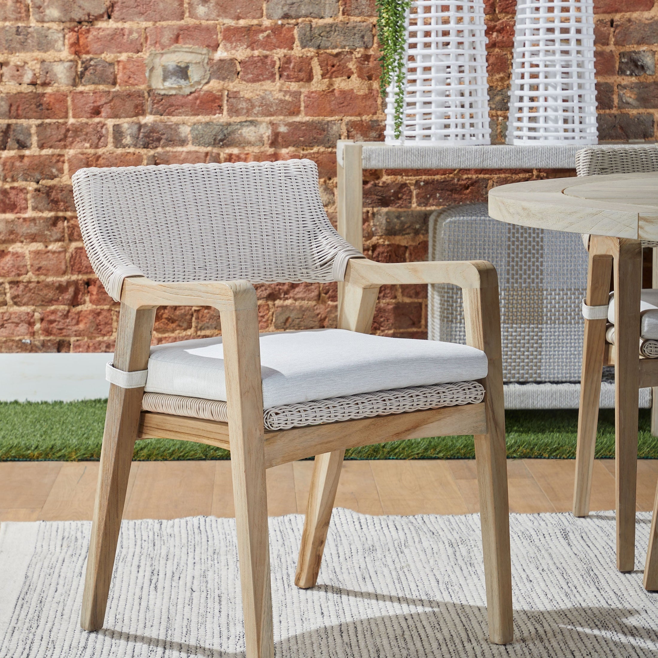 Essentials for Living Lucia outdoor arm chair with white wicker and gray teak frame with all-weather cushion outdoors