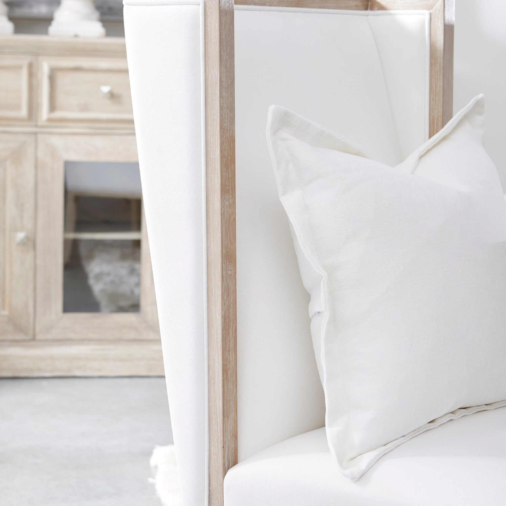 Close-up of Essentials For Living Martin Wing Chair with white upholstery and natural gray rubberwood frame