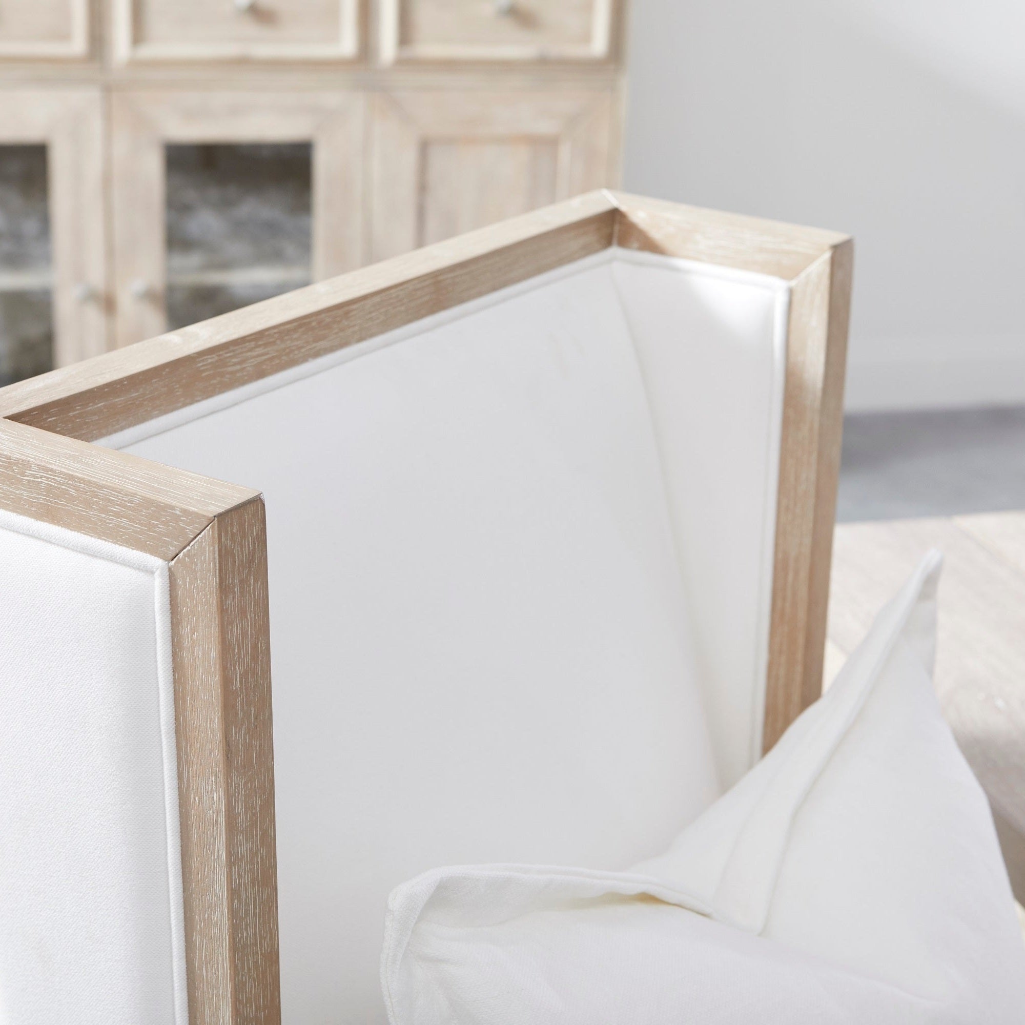 Close-up of Essentials for Living Martin Wing Chair frame in natural gray with white upholstery and pillow.