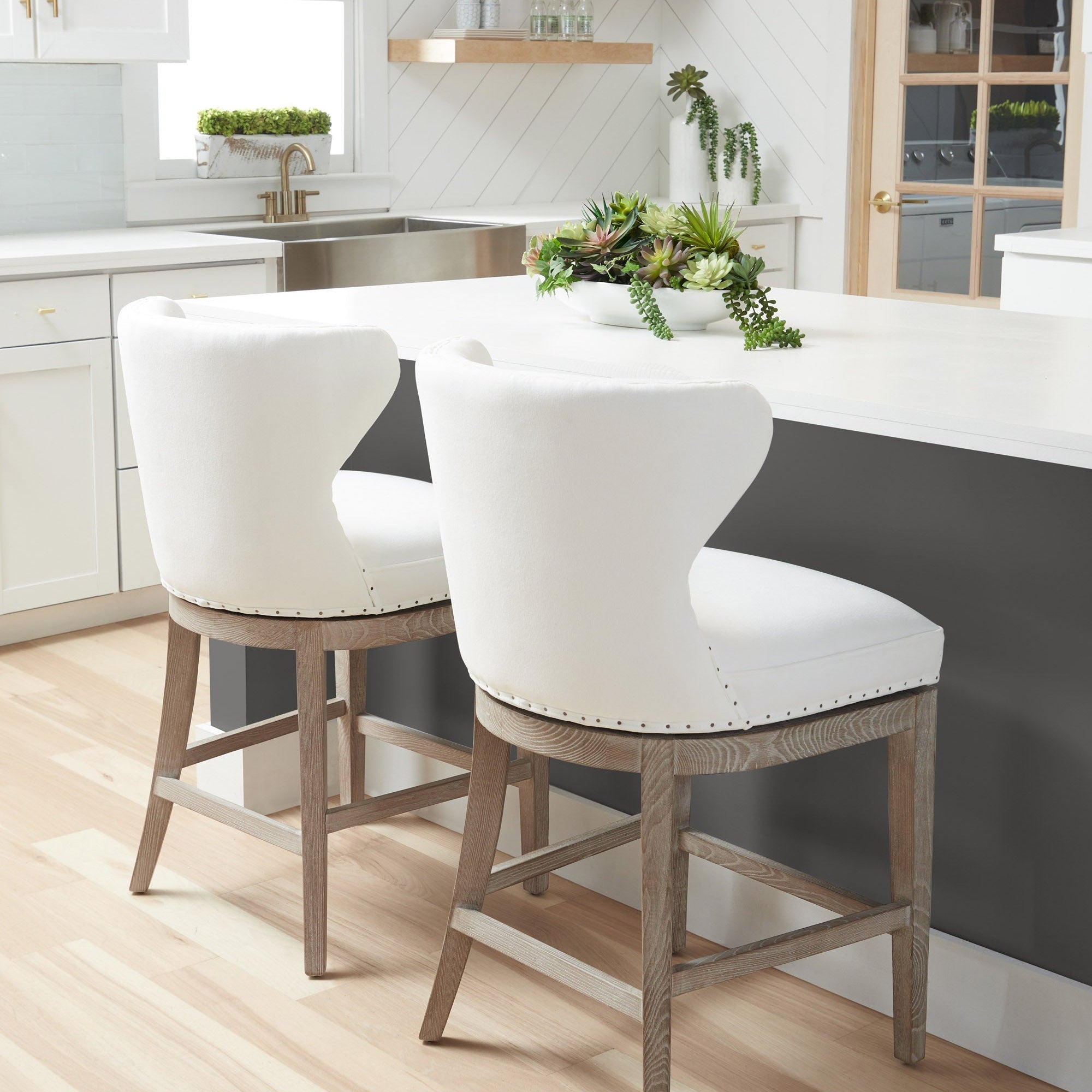 Two Essentials For Living Milton swivel counter stools with white upholstery and natural gray ash-wood frames in a modern kitchen