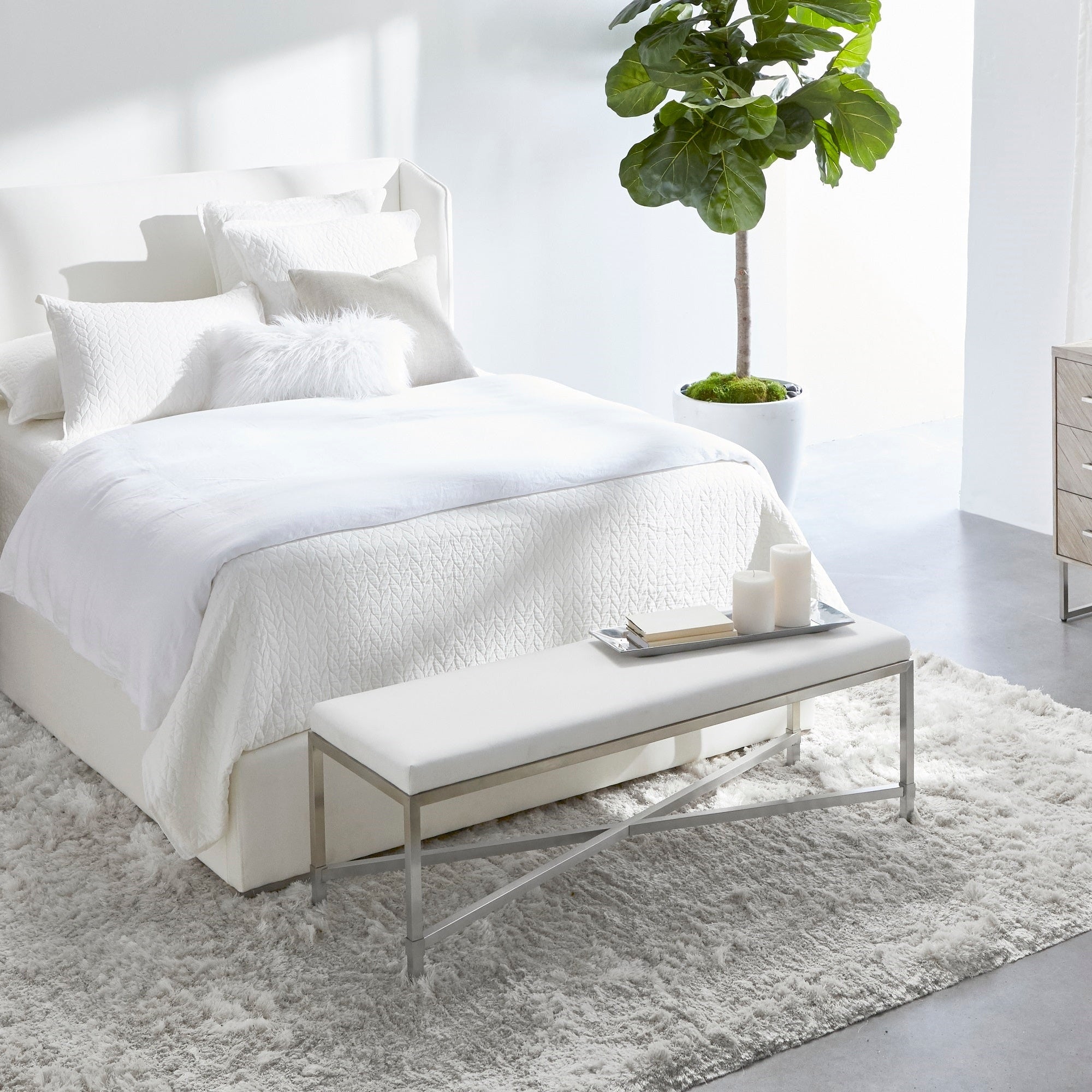 White bedroom with modern bench and partial view of the Mosaic 6-Drawer Double Dresser by Essentials for Living