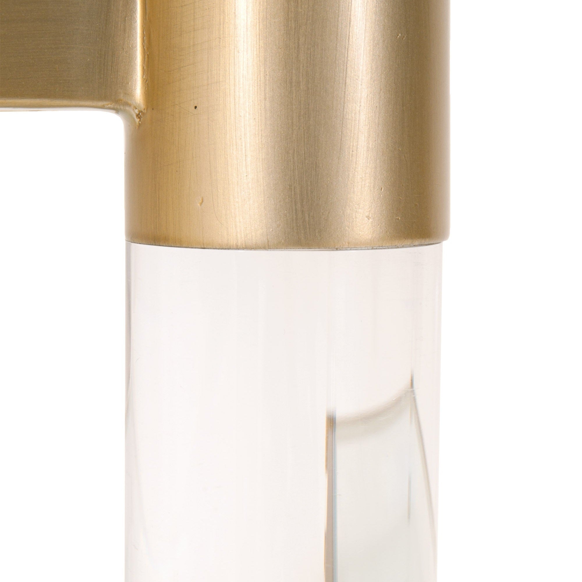 Close-up of brushed brass and clear Lucite leg detail on the Nouveau Coffee Table by Essentials for Living.
