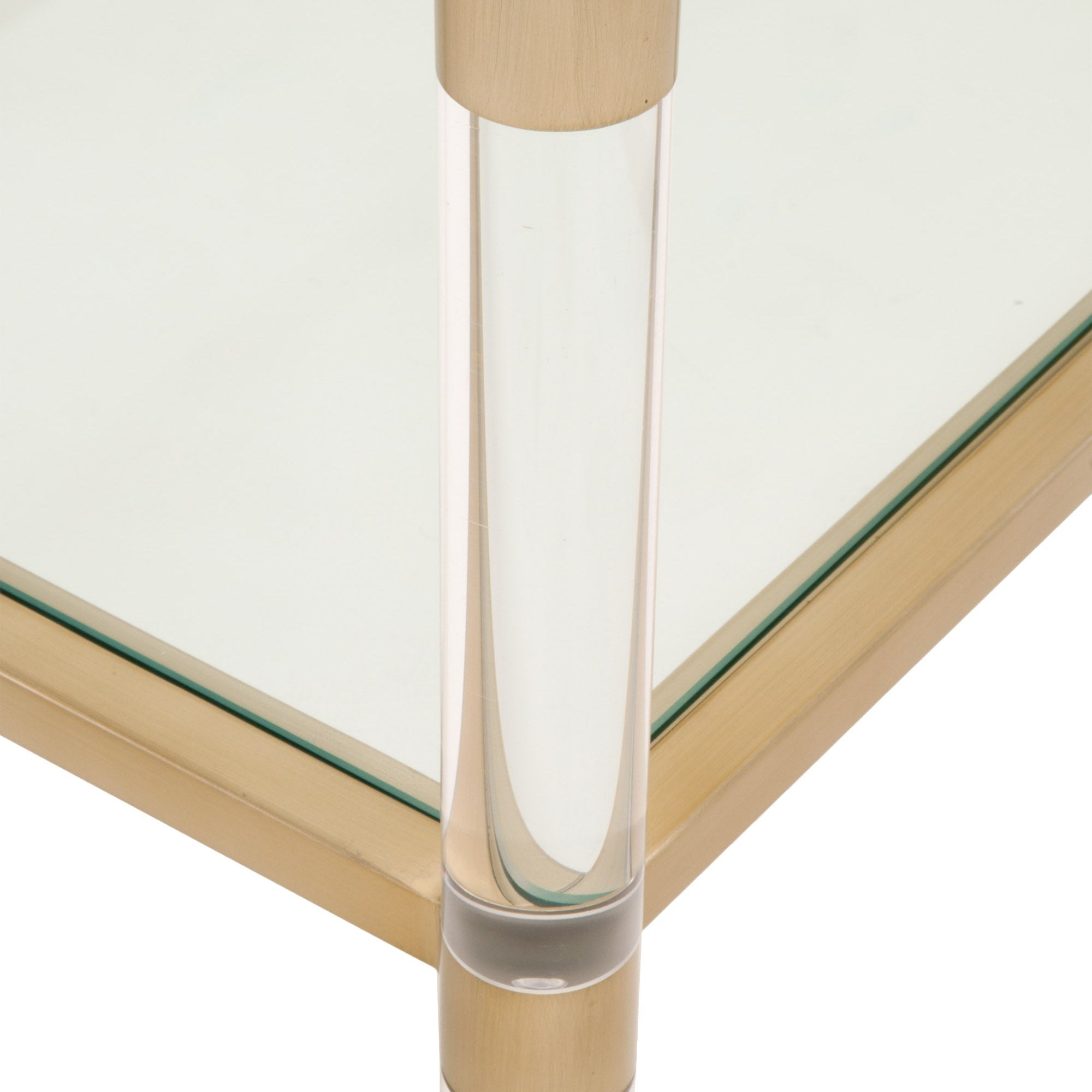 Close-up of Nouveau Coffee Table showing clear tempered glass top with brushed brass frame and lucite leg by Essentials For Living