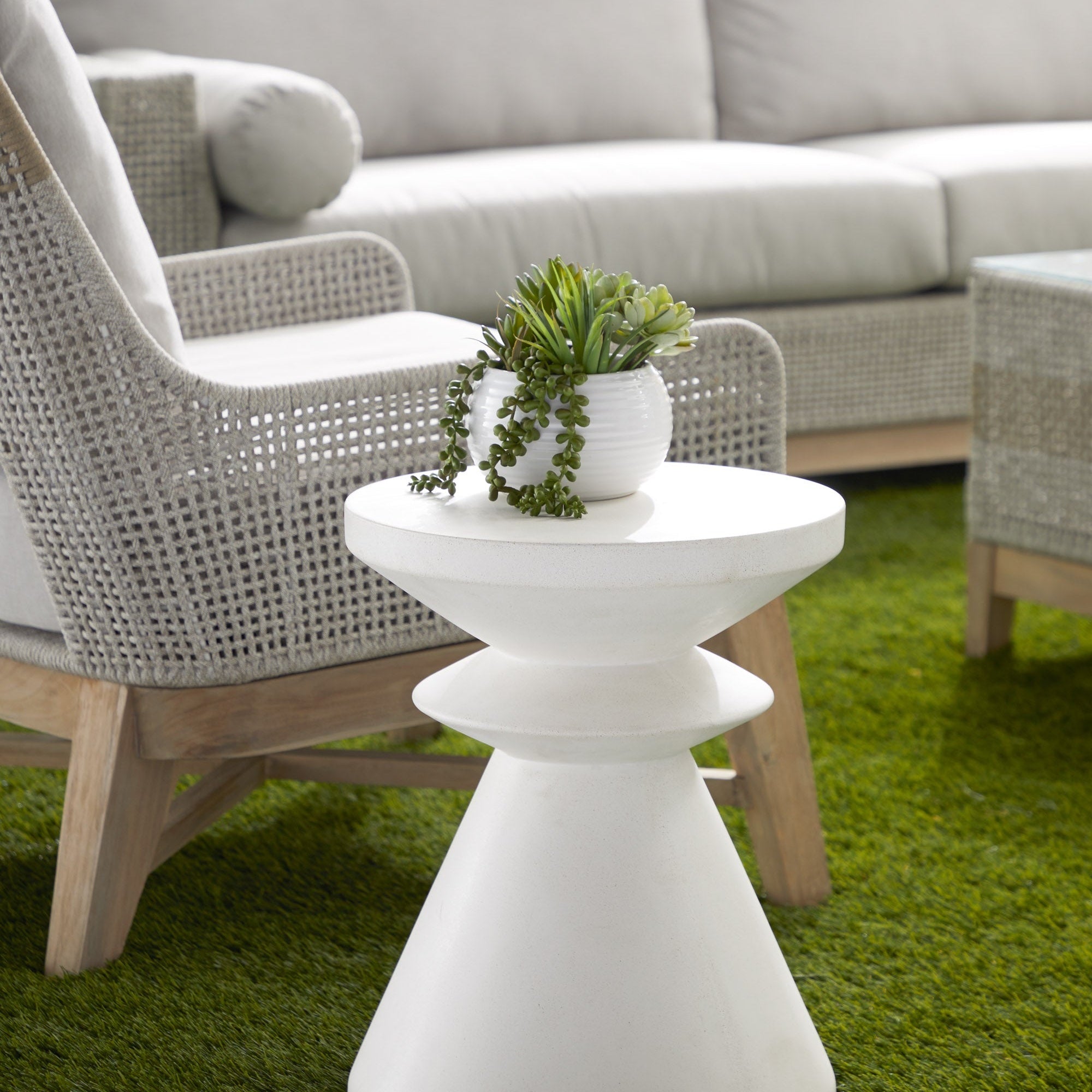 Essentials for Living Pawn Accent Table in ivory nano-sealed concrete with sculptural chess pawn design in modern outdoor setting