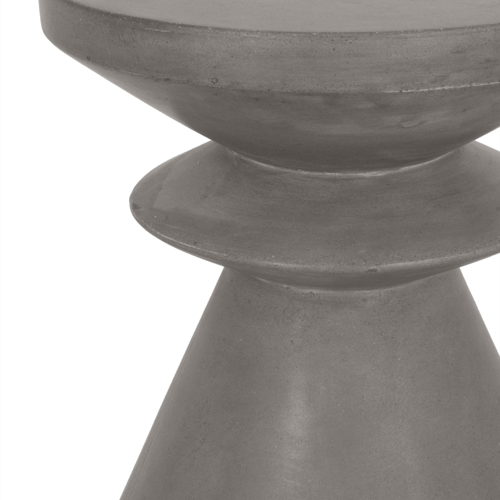 Close-up of a smooth, sculptural concrete accent table base with a modern geometric design.