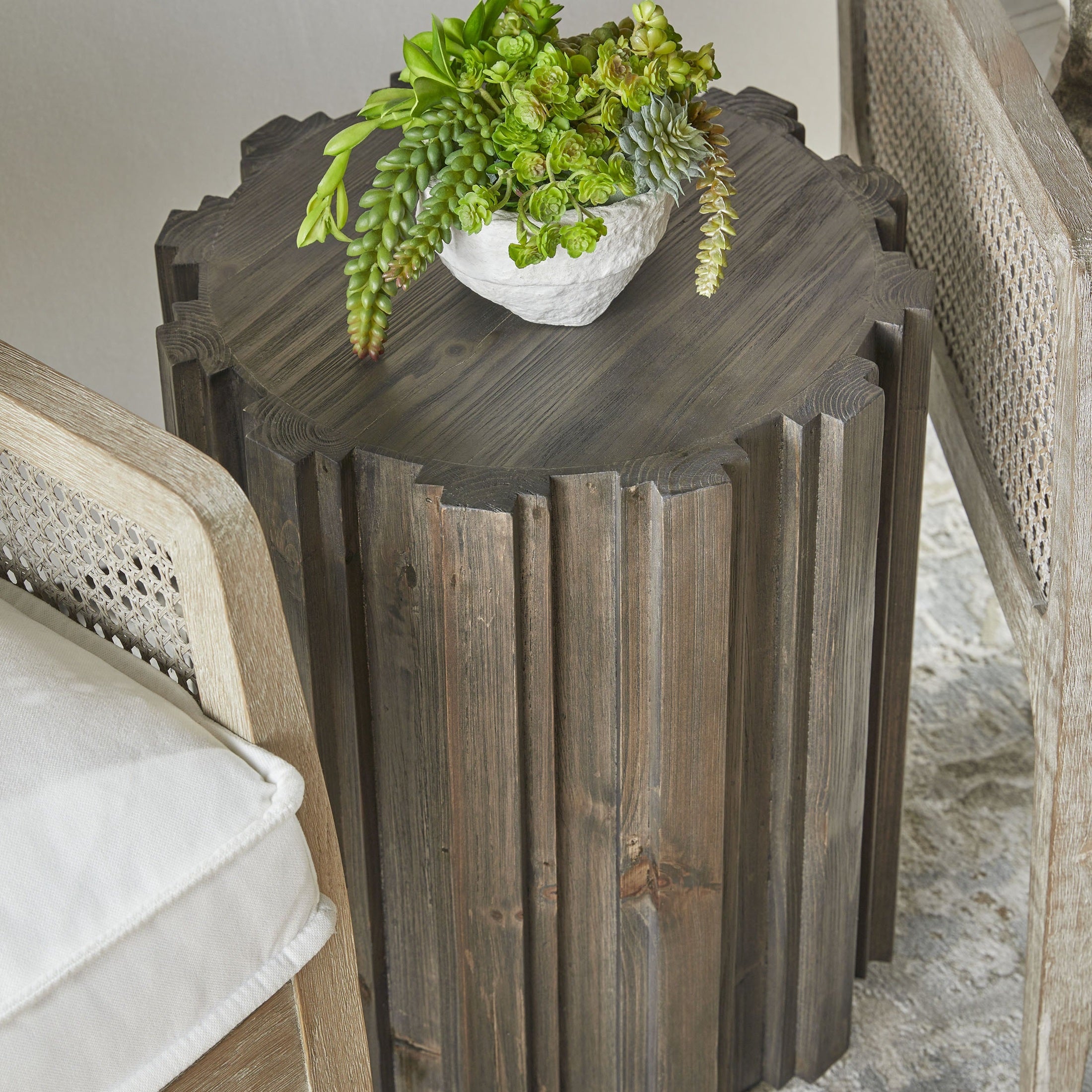 Essentials for Living Roma Accent Table in drift brown reclaimed pine with fluted pedestal and round top beside seating.