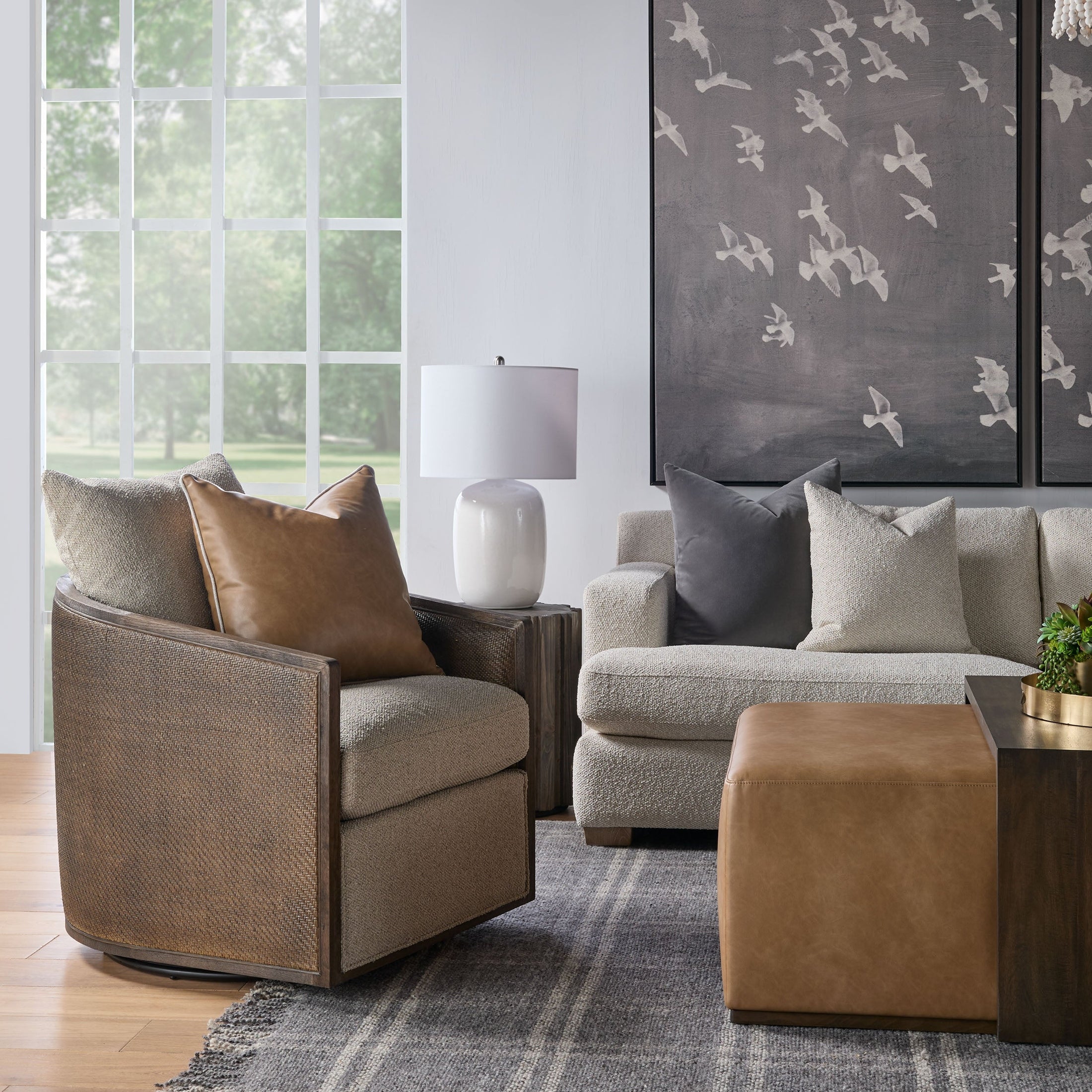 Cozy living room featuring a brown leather and fabric swivel chair with beige sofa and modern decor.