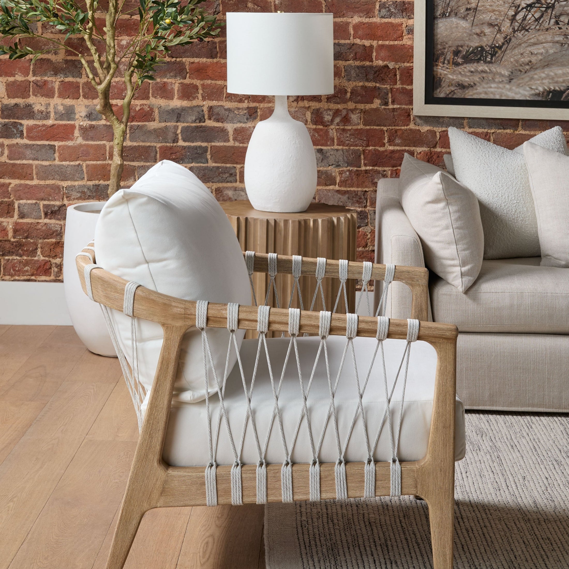 Round Roma End Table with smoke-gray wood fluting and plinth base by Essentials For Living in a modern living room setting