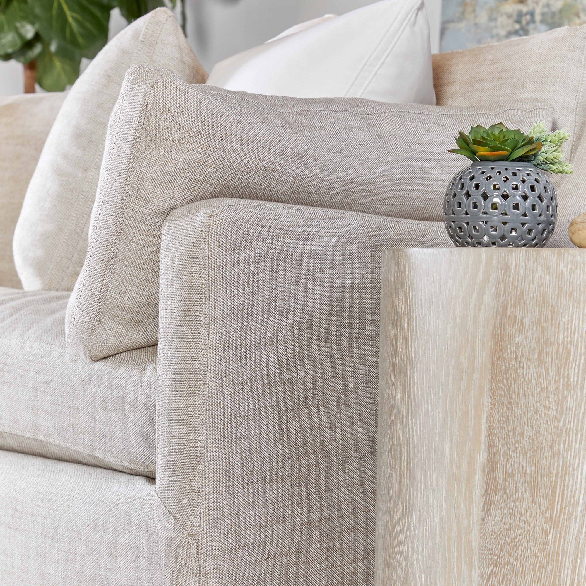 Close-up of Roto Large End Table in natural gray oak finish next to beige sofa by Essentials for Living.
