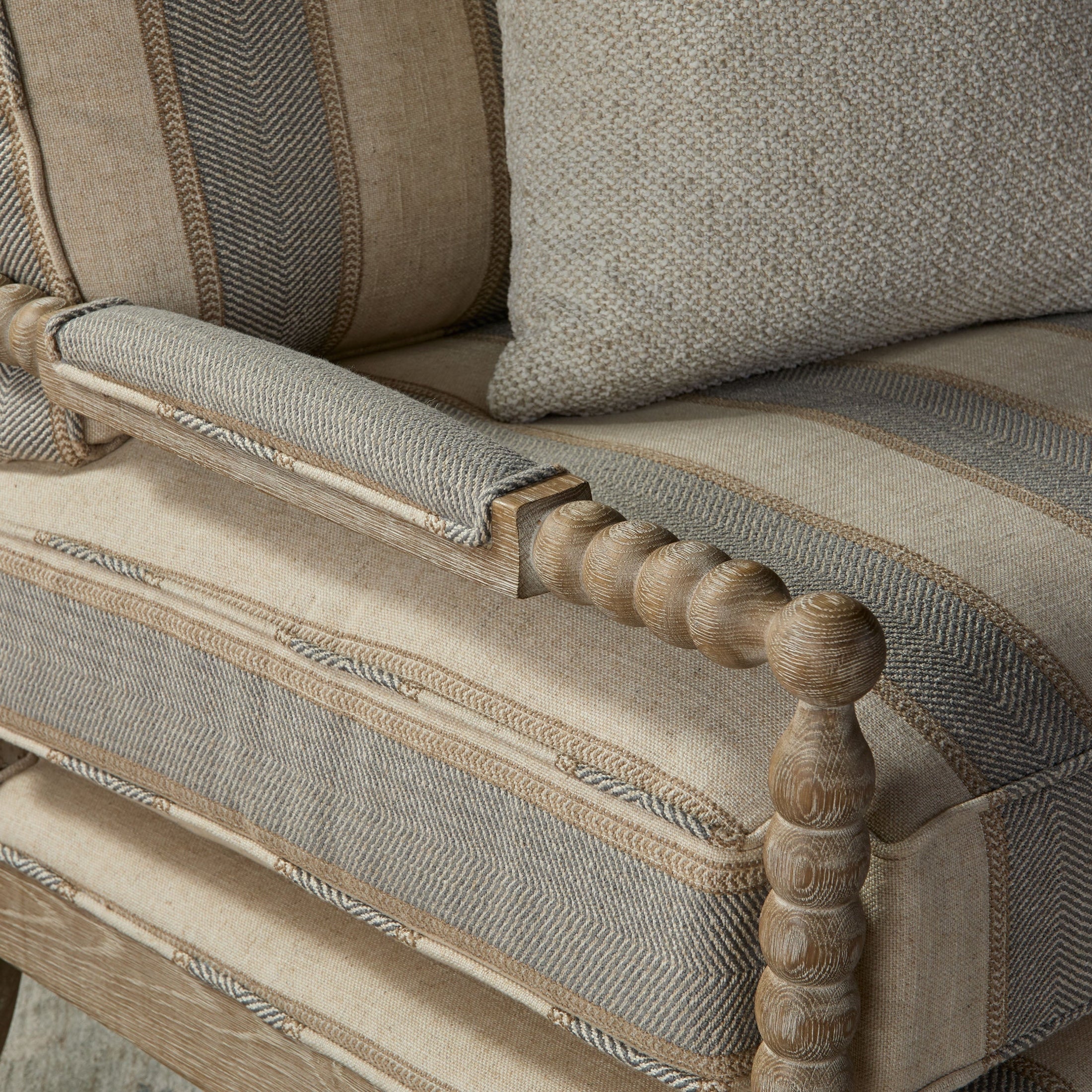 Close-up of Rouleau Club Chair’s carved natural gray oak arm with soft textured upholstery by Essentials for Living