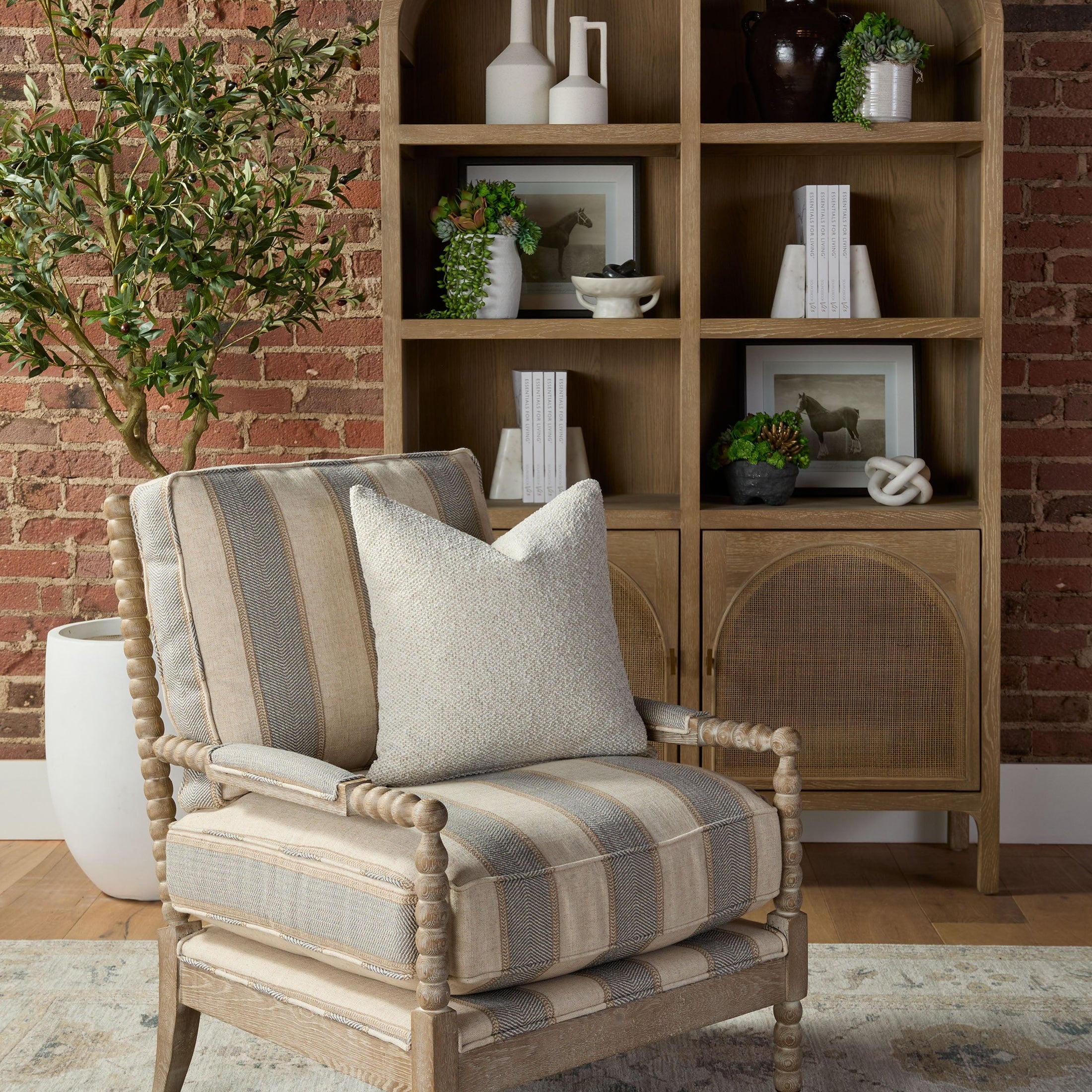 Essentials for Living Rouleau Club Chair with carved wood frame and striped cushioned upholstery in a cozy living room setting