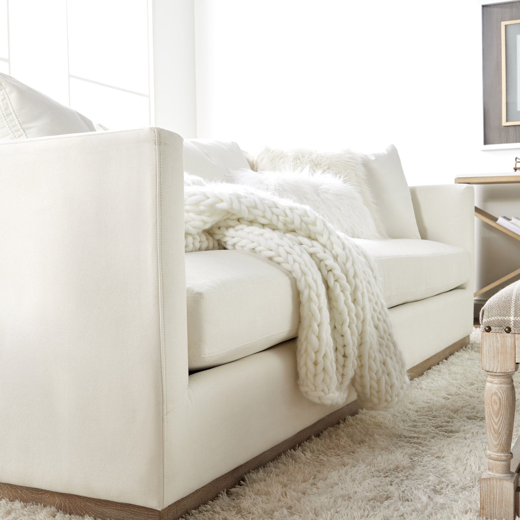 Ivory Siena 96" sofa by Essentials for Living with plush cushions and a cozy knit throw in a bright living room.