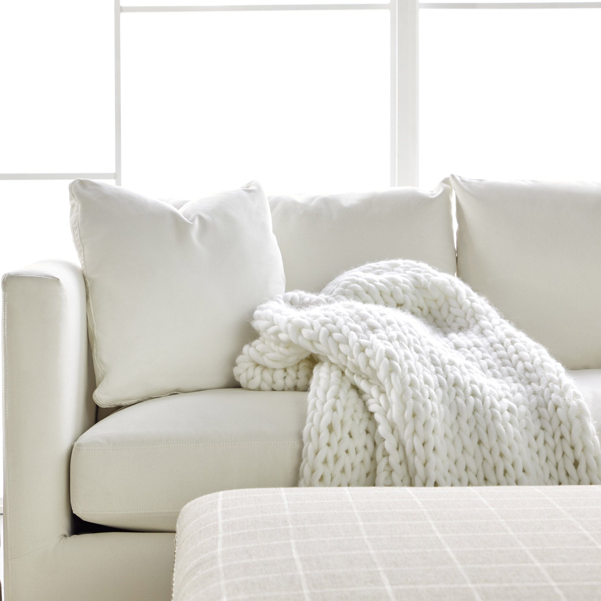 Essentials For Living Siena 96" sofa in ivory with plush cushions and chunky knit throw for cozy modern living room style.