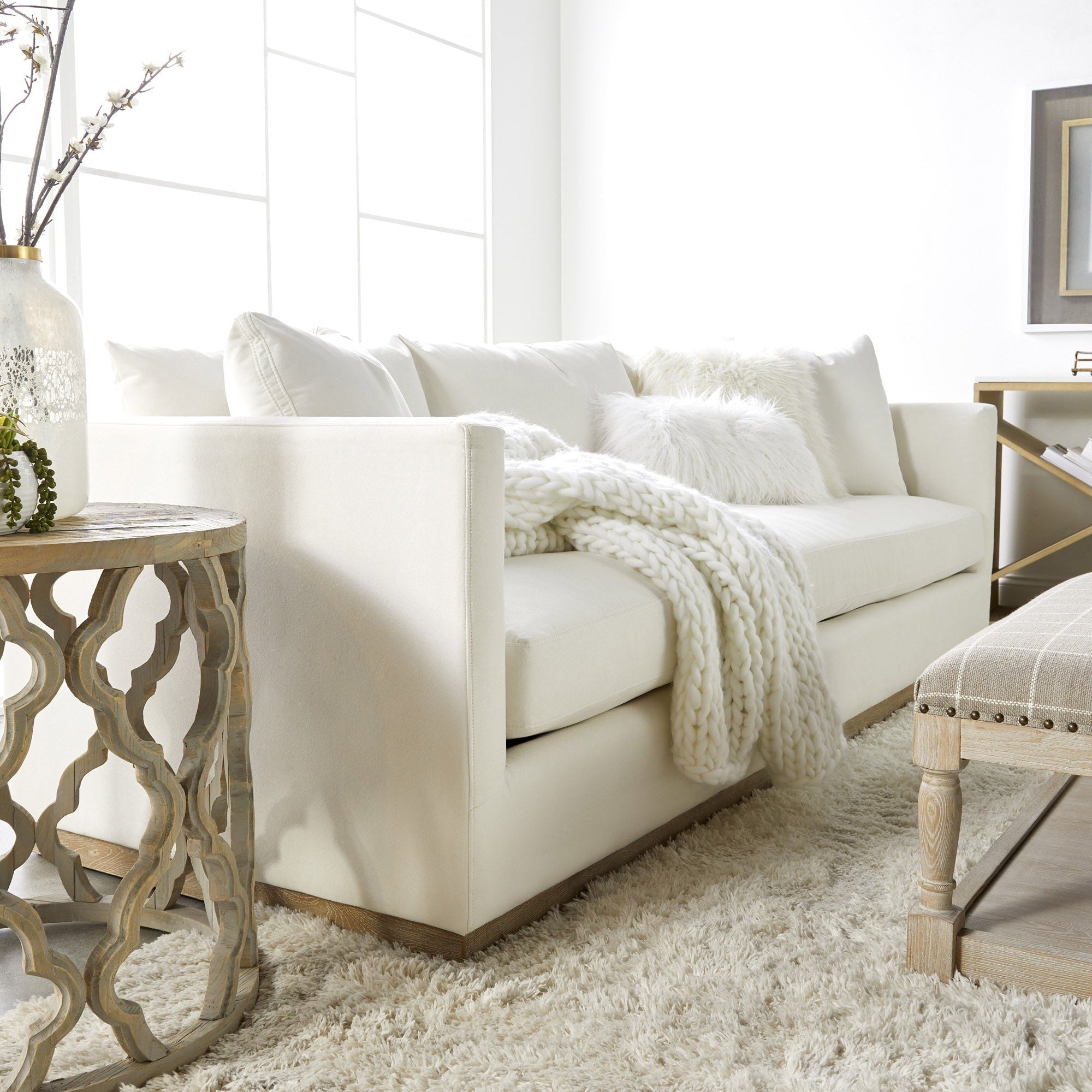 Ivory Siena 96" sofa by Essentials for Living with plush cushions and wood plinth base in a bright living room.