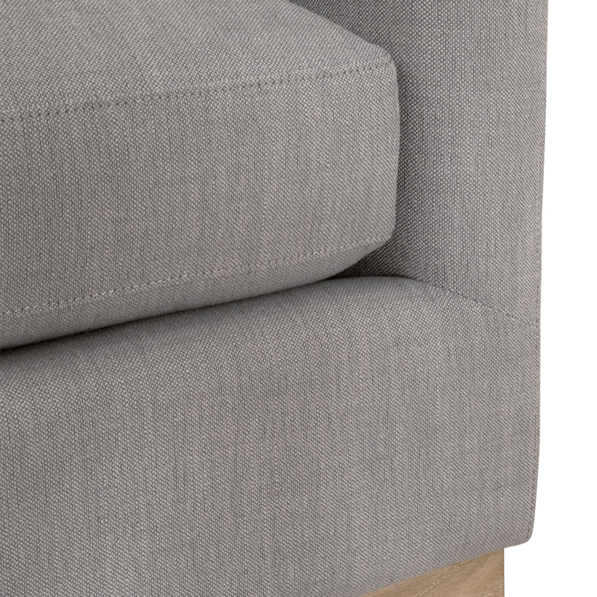 Close-up of the grey fabric upholstery and wood plinth base detail on the Essentials for Living Siena sofa.