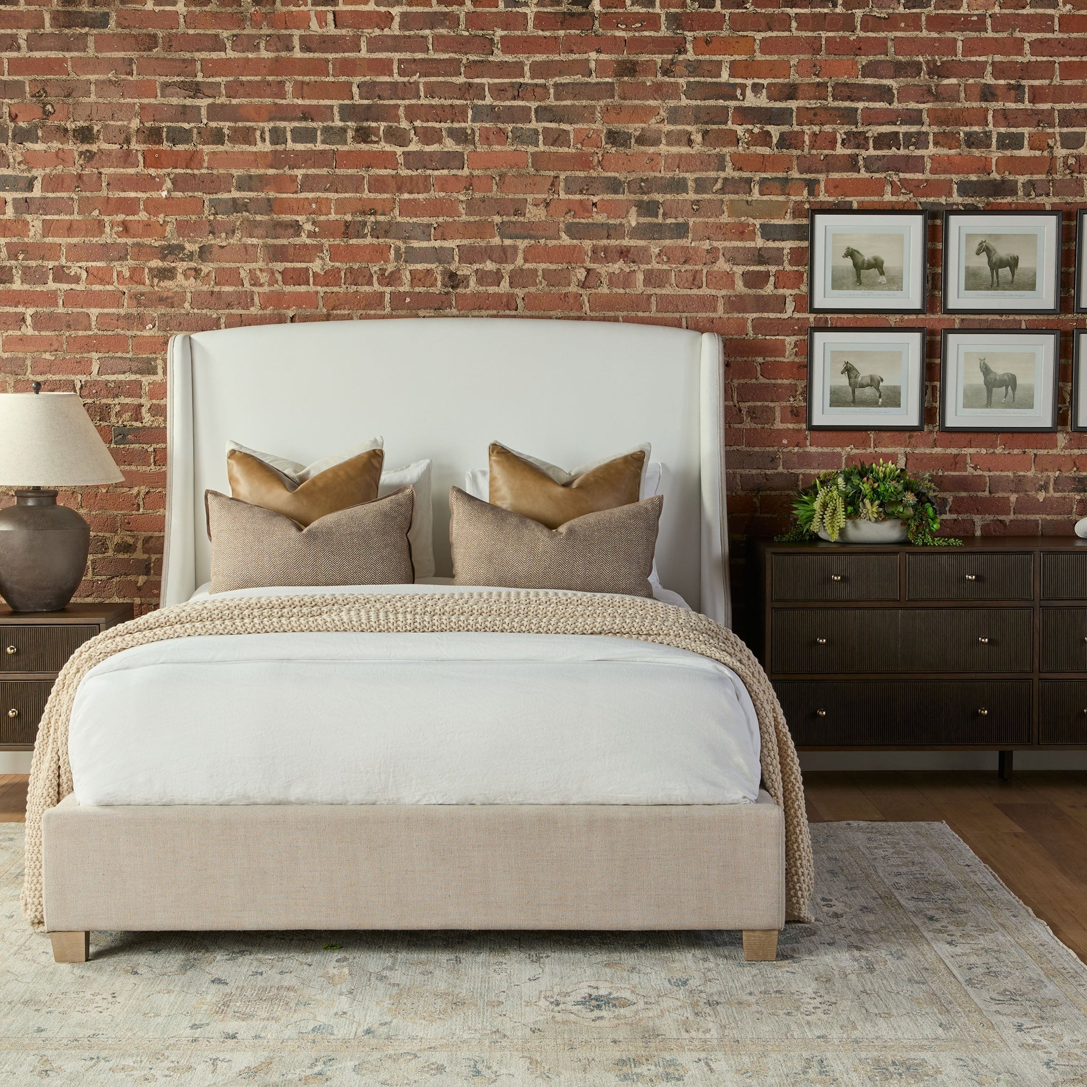 Sloan Standard King Bed with upholstered arched headboard, natural gray oak legs, and neutral bedding in cozy bedroom setting