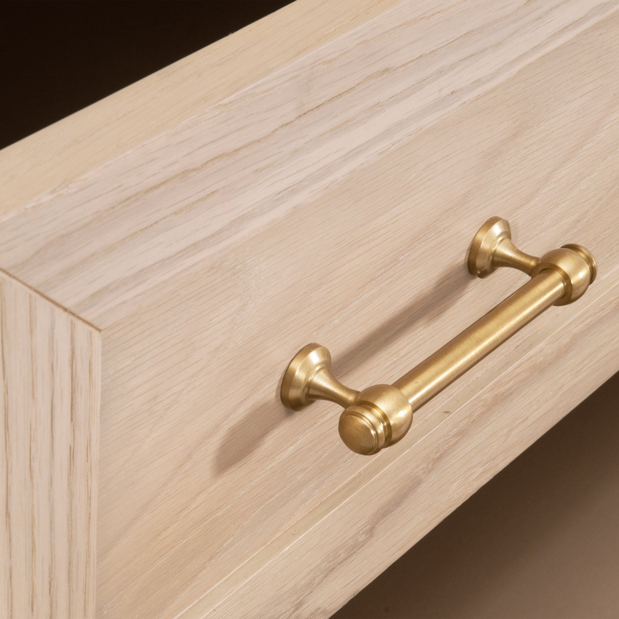 Close-up of brushed brass handle on light wood drawer of Stella 6-Drawer Double Dresser by Essentials for Living