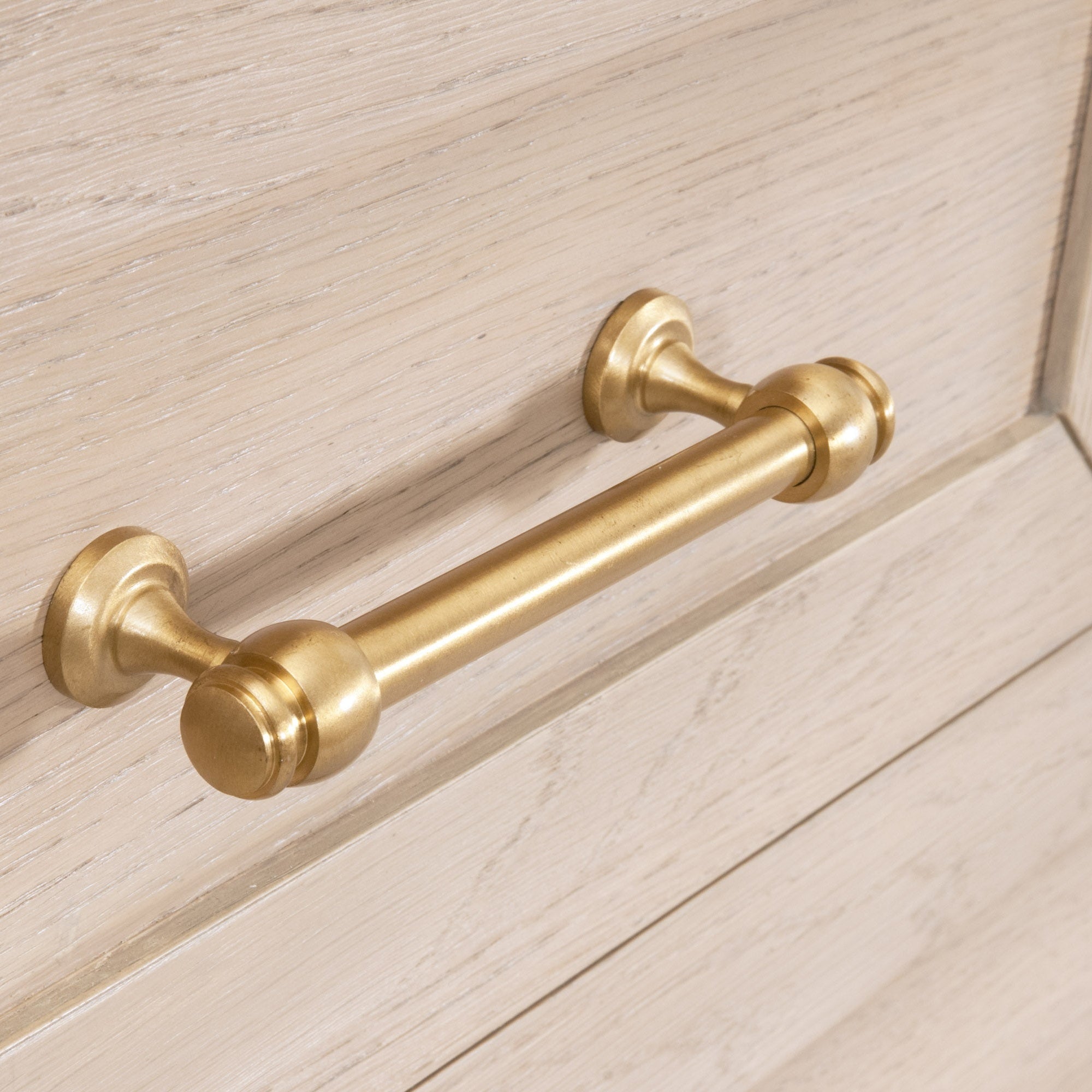 Close-up of brushed brass drawer handle on light wood drawer from Essentials for Living Stella high chest