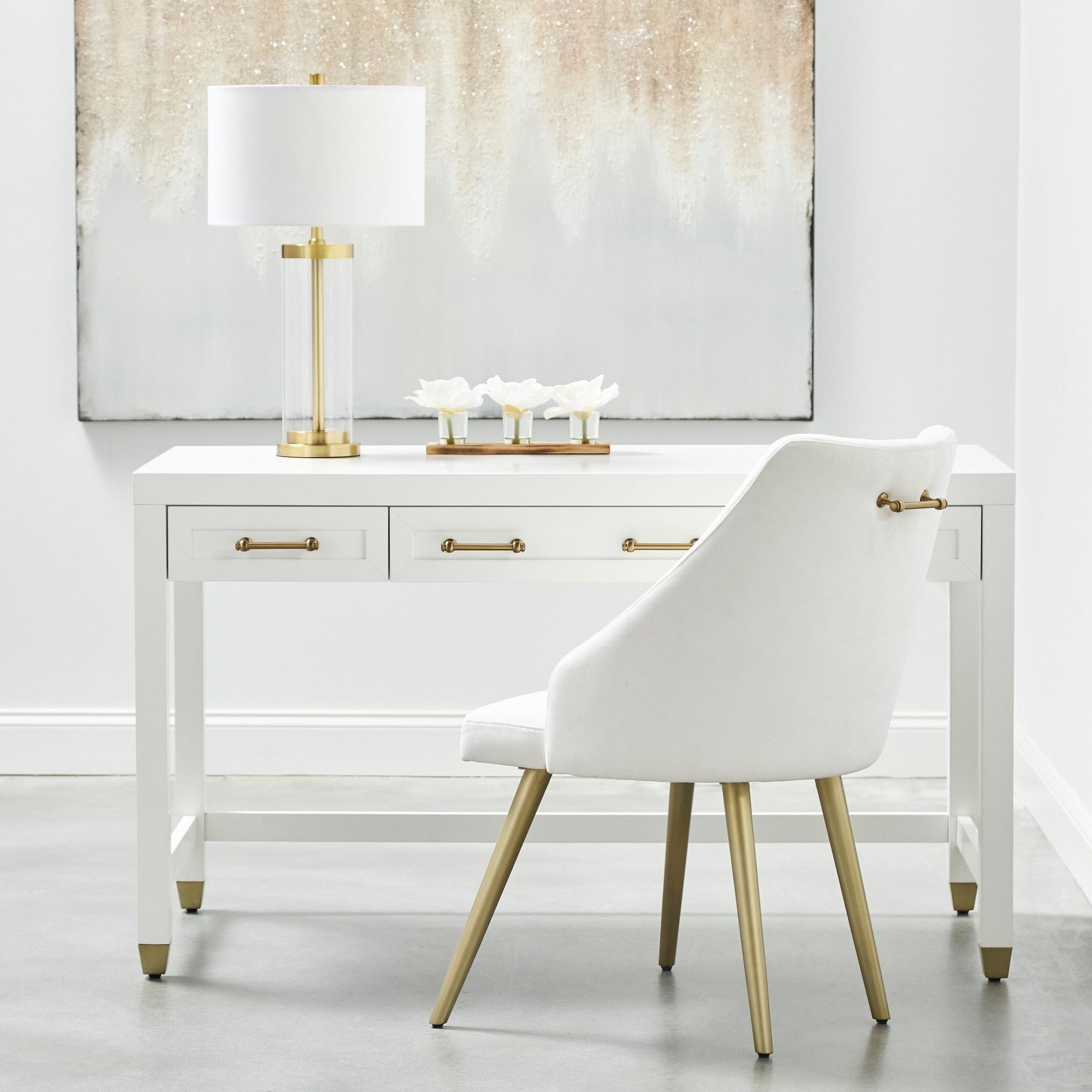 Sleek white Stella Desk by Essentials For Living with brass handles and feet, three drawers, paired with modern white chair.