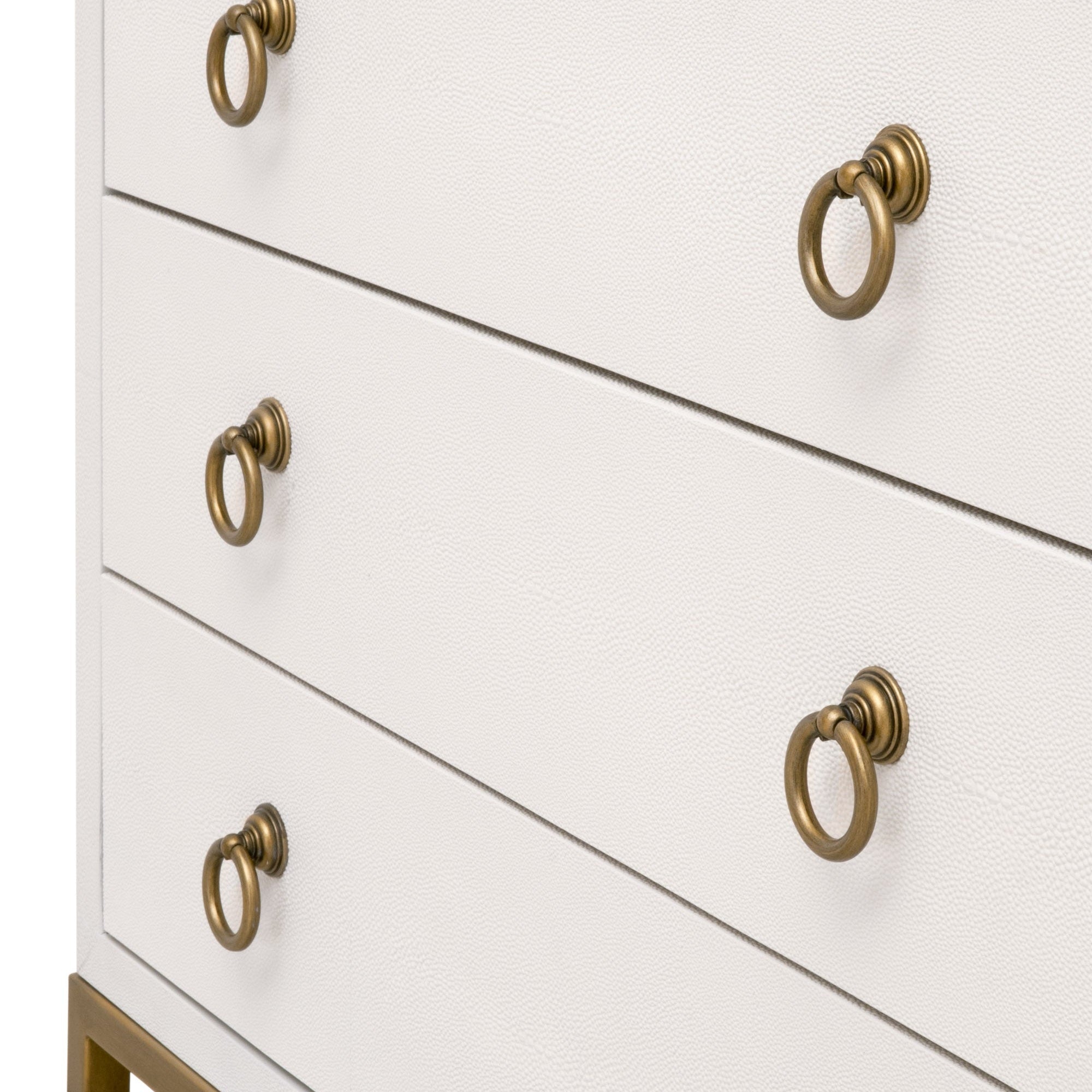 Close-up of white faux shagreen nightstand drawers with brushed gold ring pulls and gold metal base detail