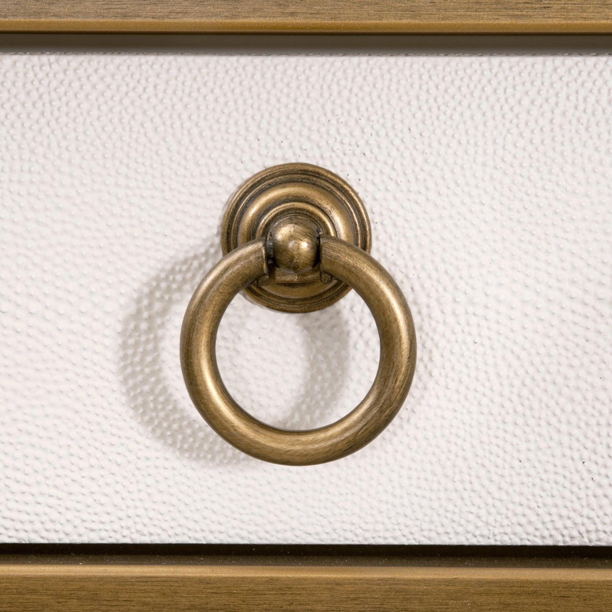 Close-up of brushed gold ring pull on pearl white faux shagreen resin drawer of Essentials for Living Strand Shagreen Desk