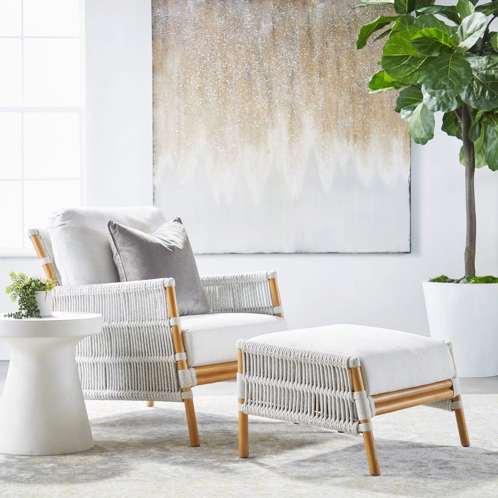 Essentials For Living Tack Accent Table in ivory fiber-reinforced concrete shown beside woven lounge chair and ottoman.
