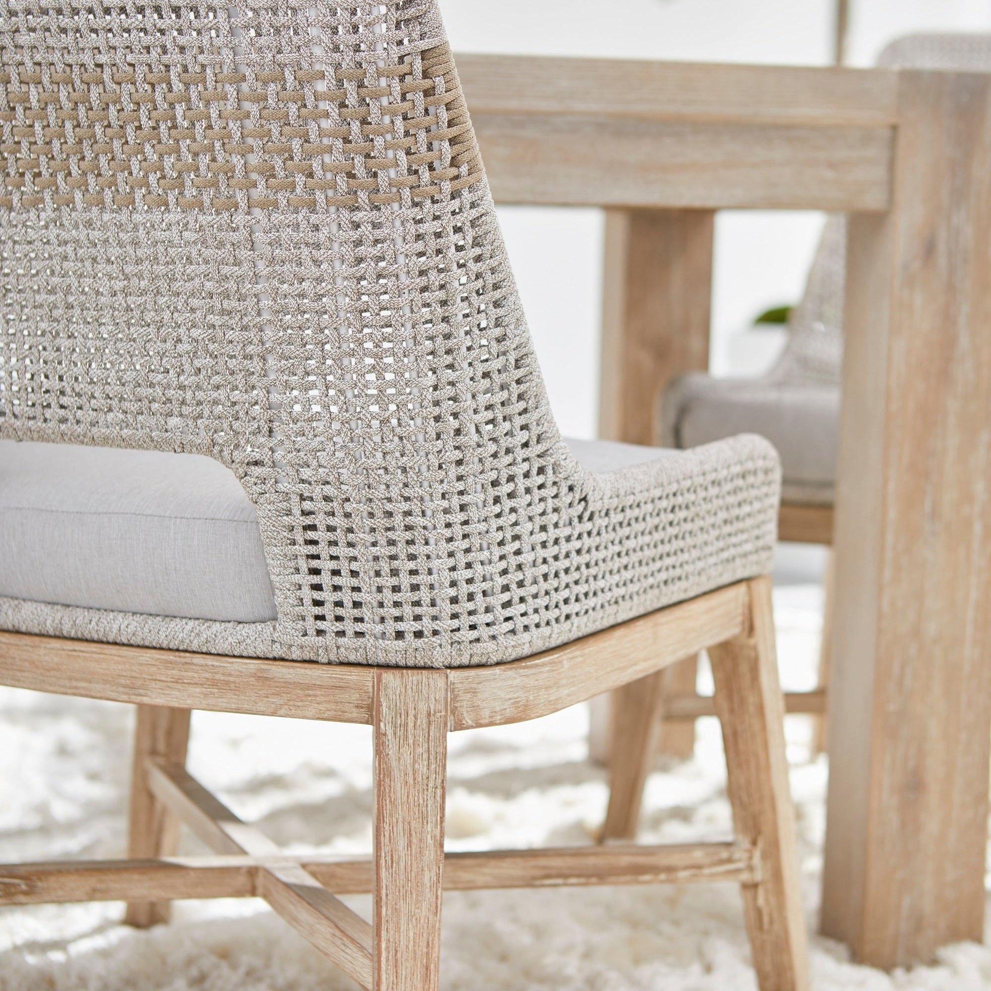 Close-up of a taupe woven tapestry dining chair with distressed natural gray mahogany legs and pumice cushion