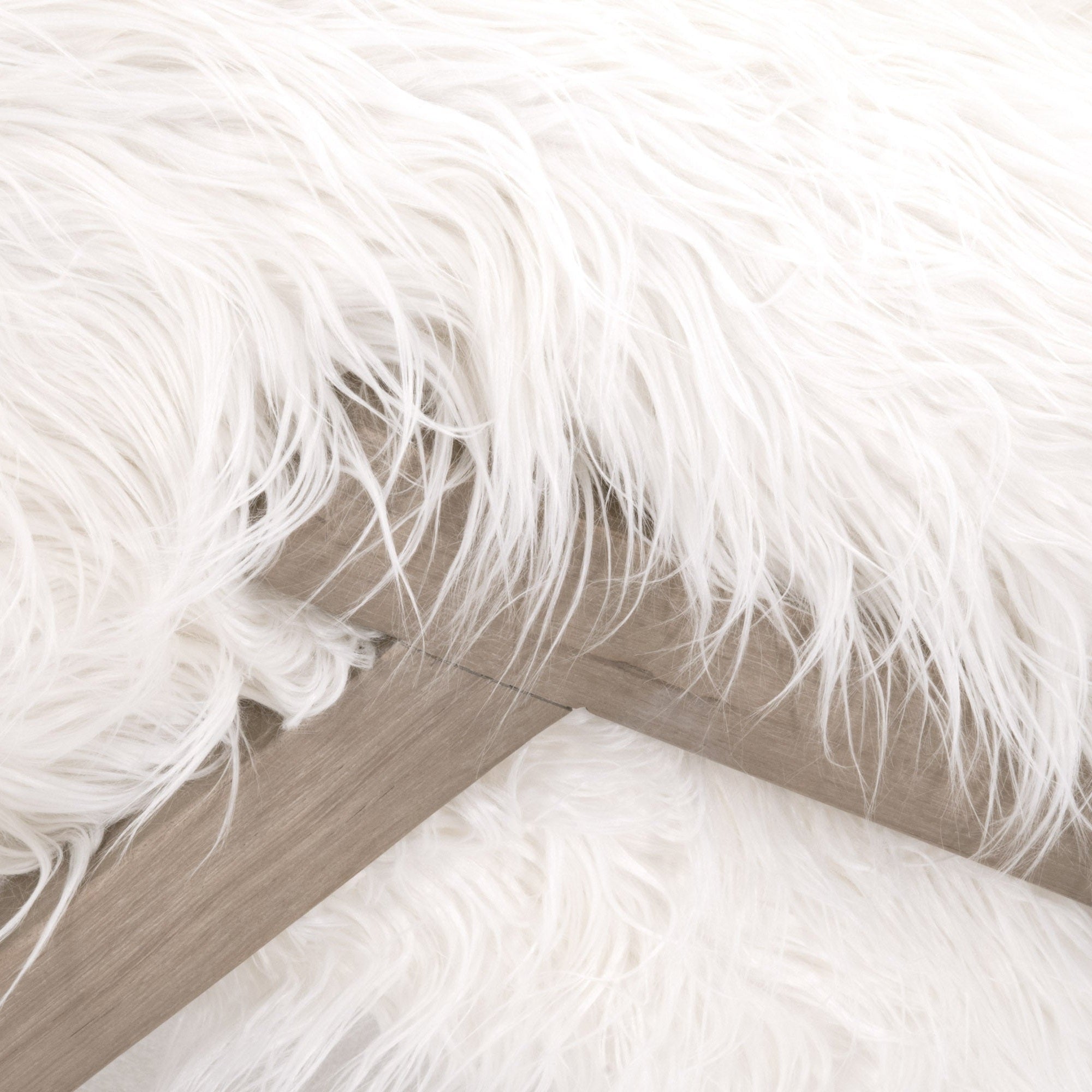 Close-up of white faux fur upholstery and smoke gray oak legs on the Tibet Ottoman by Essentials for Living