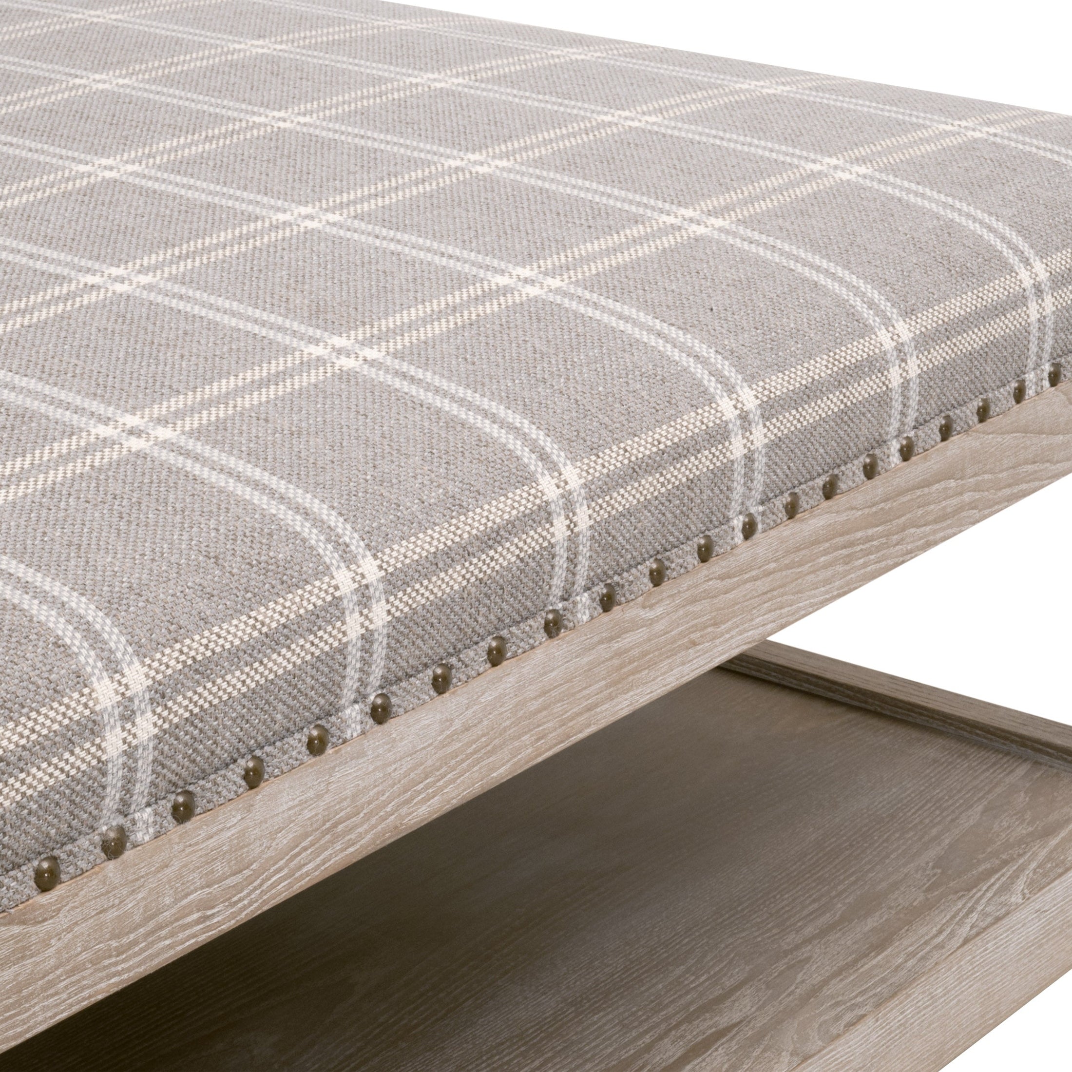 Close-up of Townsend Upholstered Coffee Table showing gray plaid fabric with gold nailhead trim and natural gray ash wood base