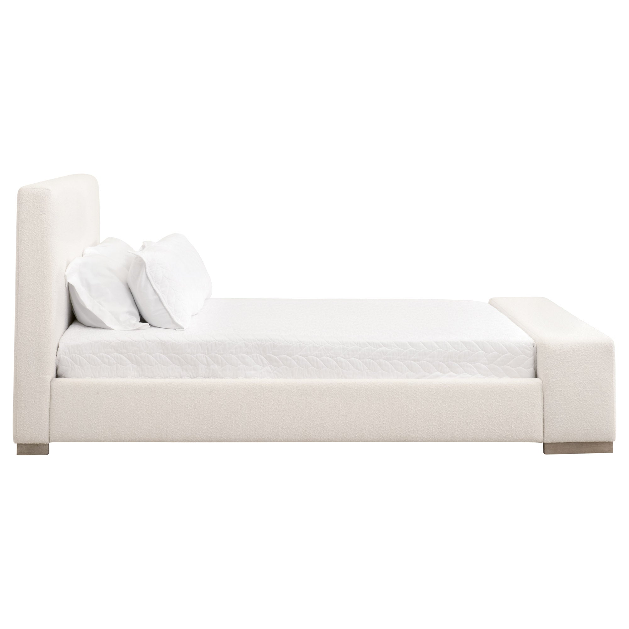 Side view of a white upholstered Warren Standard King Bed with pillows and an extra-wide footboard bench
