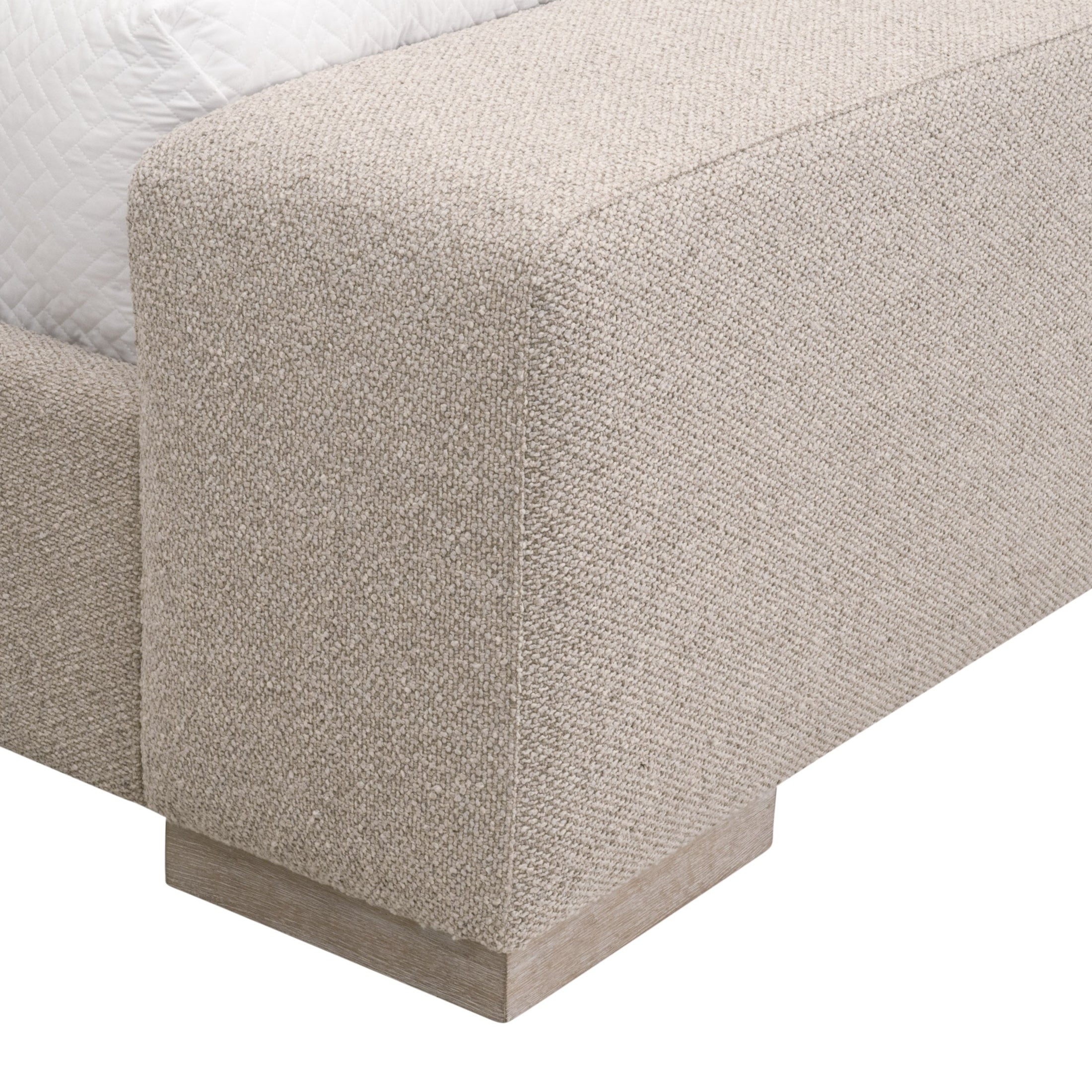 Close-up of the Warren Queen Bed’s upholstered footboard in textured snow white fabric with solid oak base by Essentials For Living
