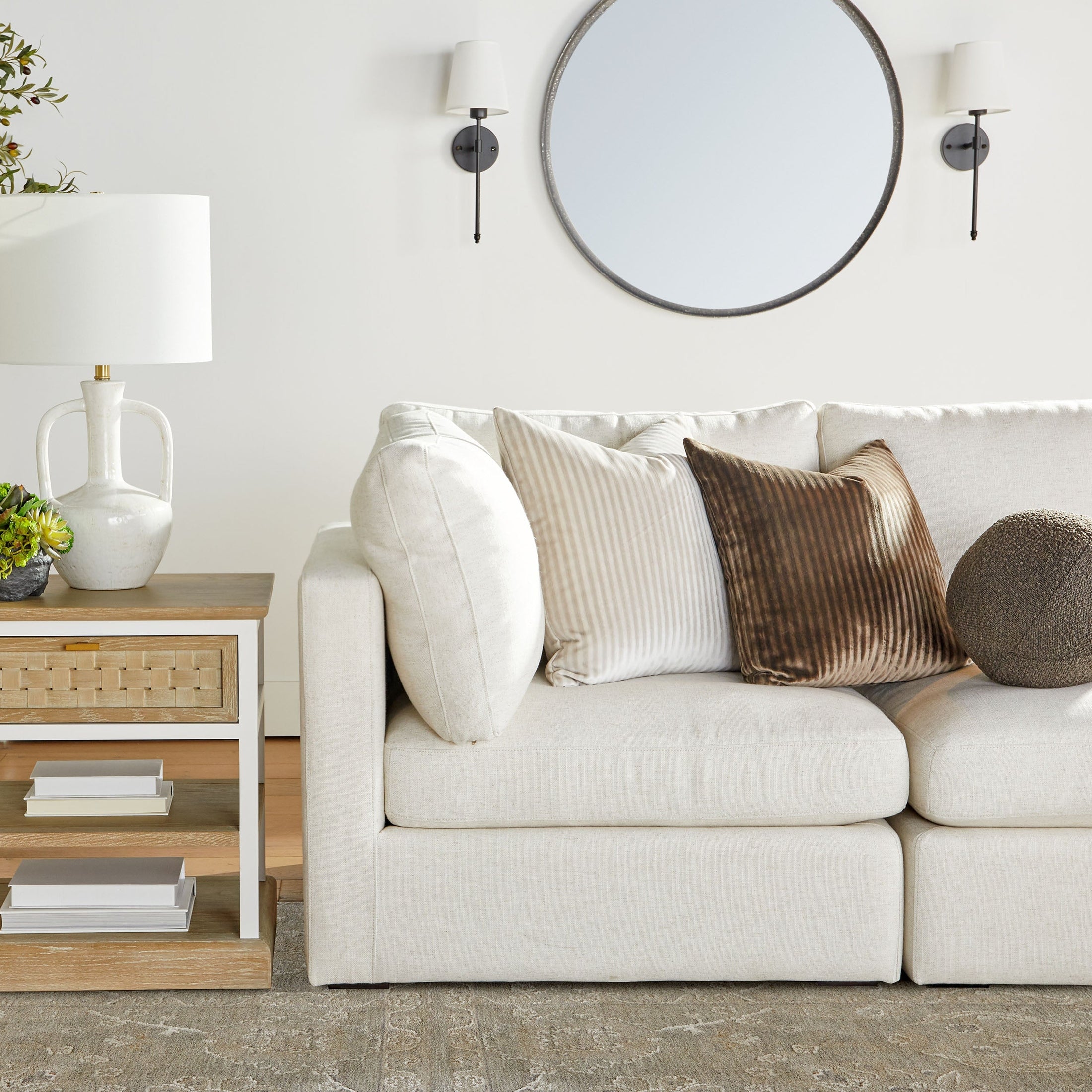 Essentials For Living Weave 1-Drawer Side Table in smoke gray and white with basket-weave drawer front next to beige sofa.