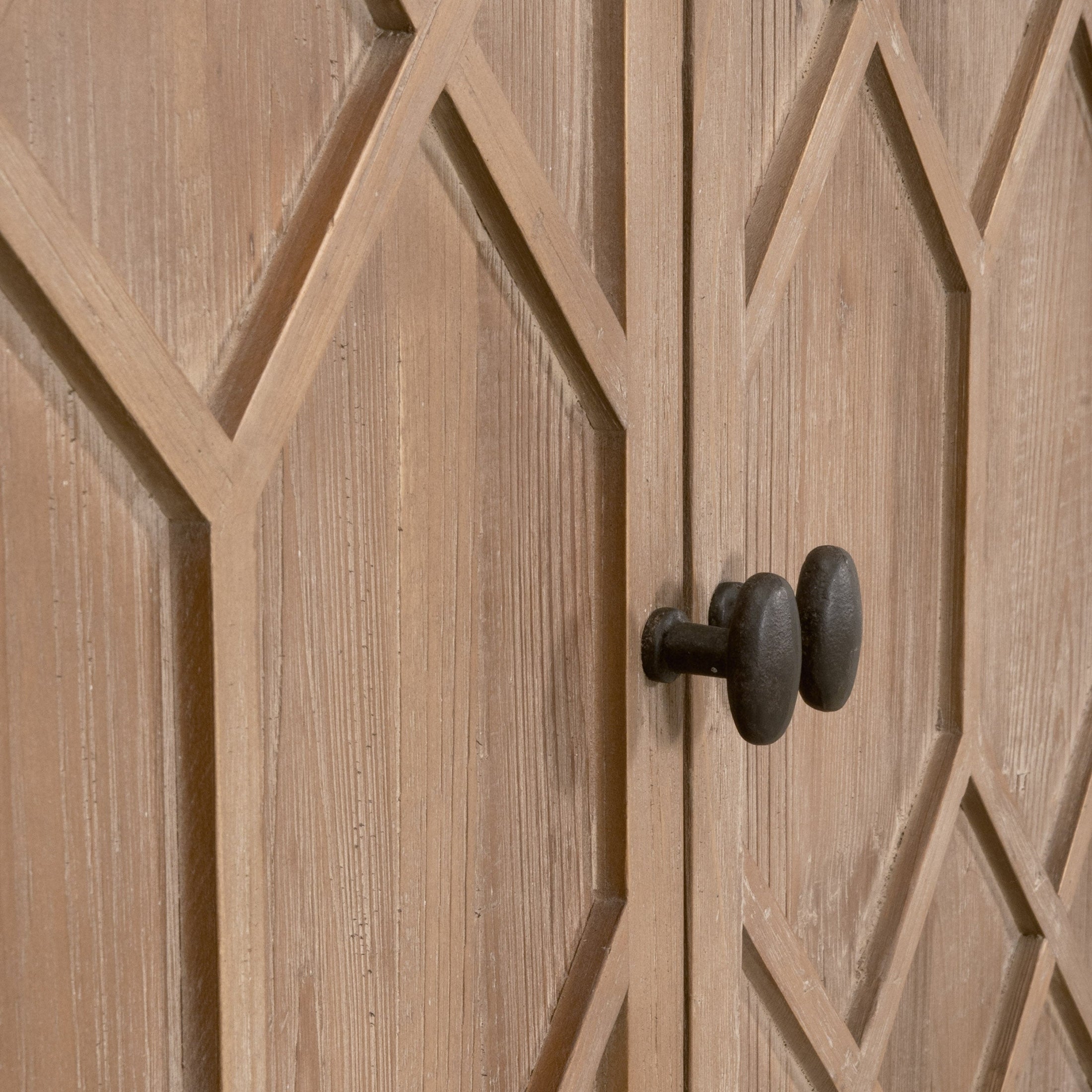 Close-up of diamond-patterned wooden doors with rustic black knobs on a farmhouse style sideboard