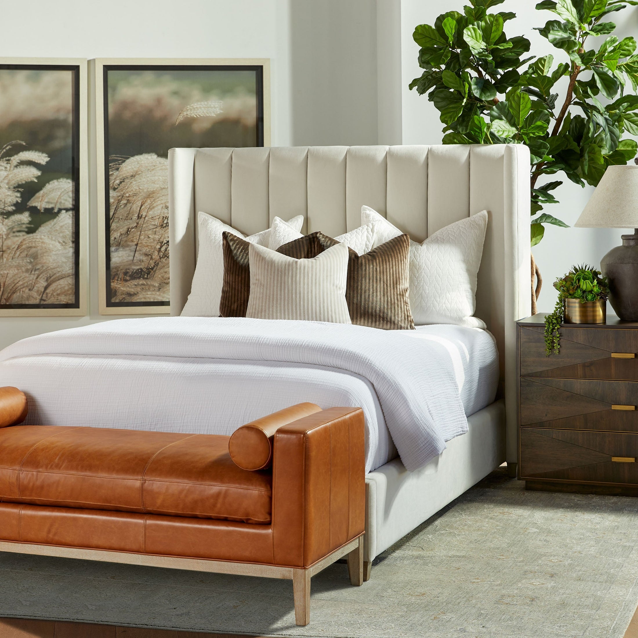 Essentials for Living Wynn nightstand in burnished brown acacia veneer with brushed gold frame beside upholstered bed.